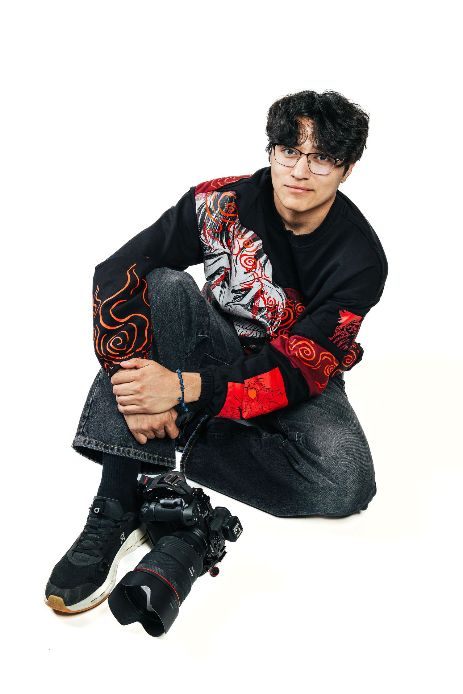 A person in black clothing with red accents poses in a sequence of crouching positions against a white background.