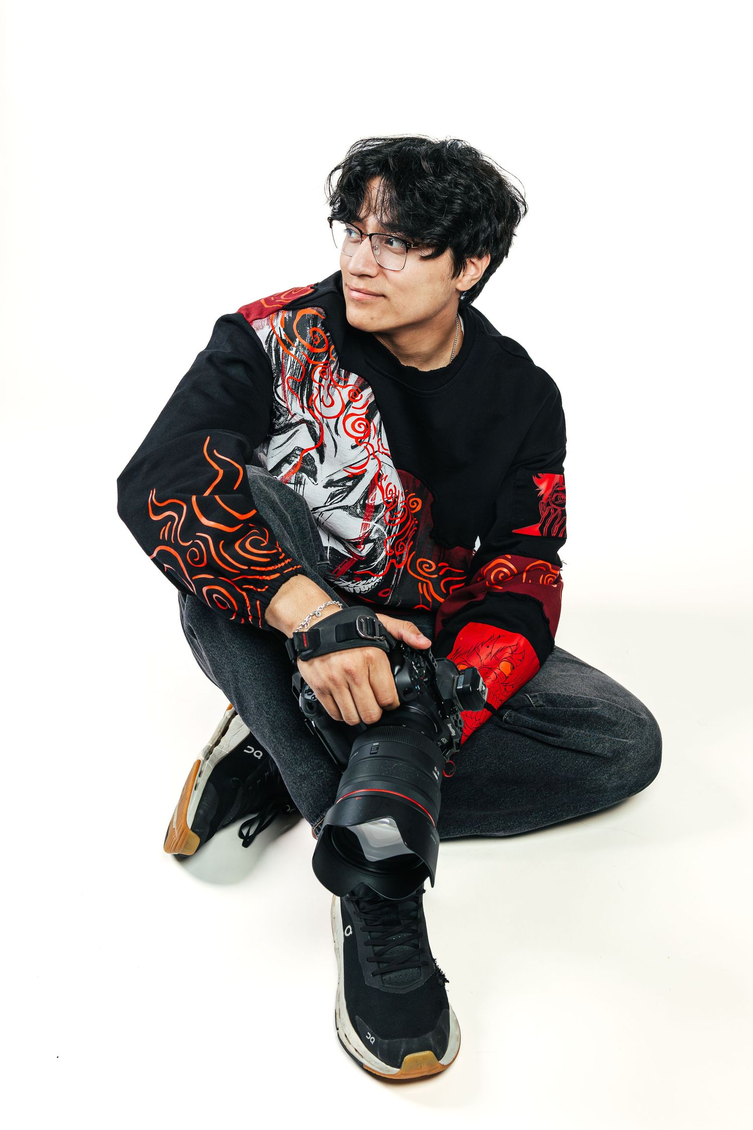 Person in black and red patterned outfit crouches in artistic poses against white background in triptych composition.