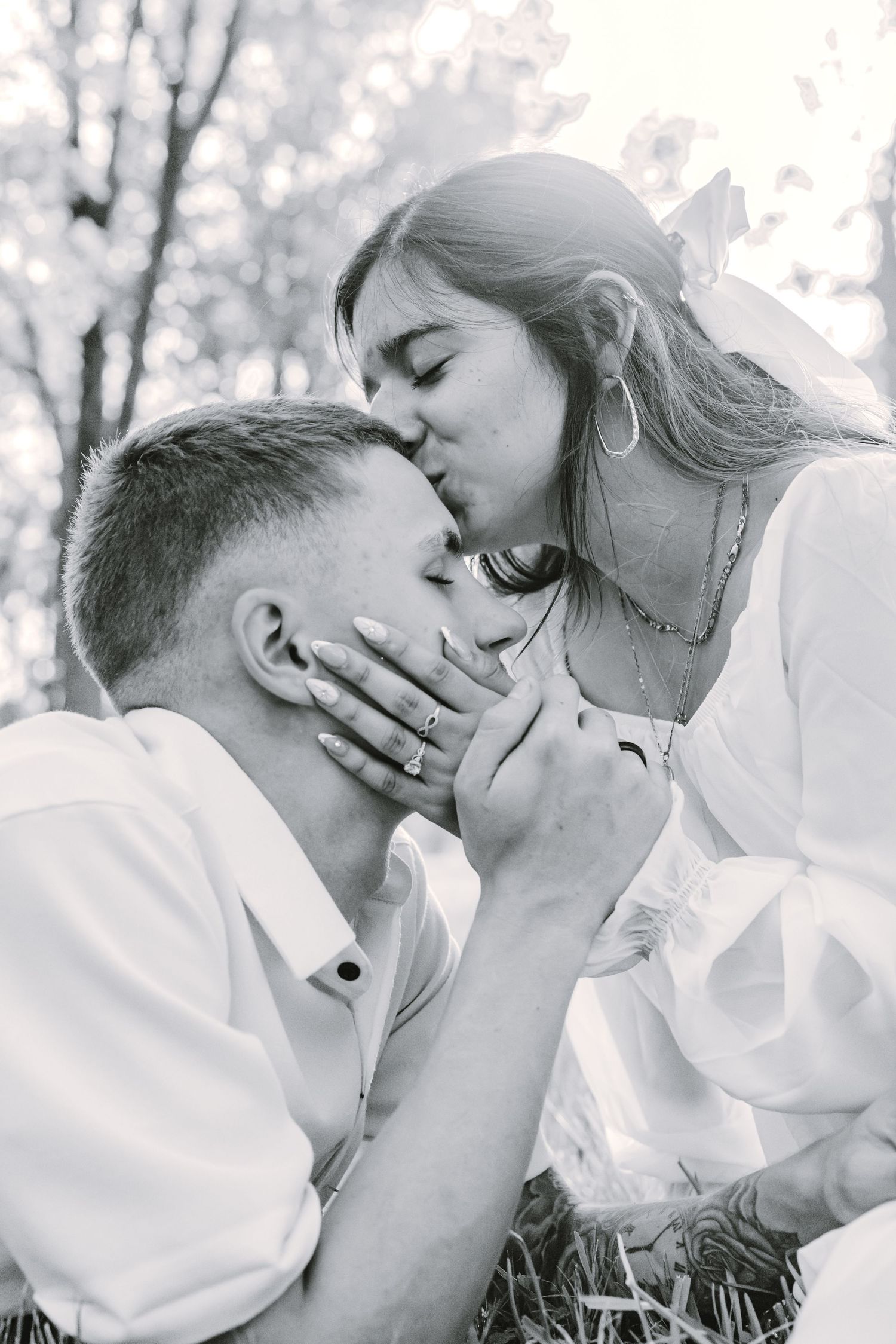 Black and white romantic portrait of a tender intimate moment between a couple outdoors in nature.