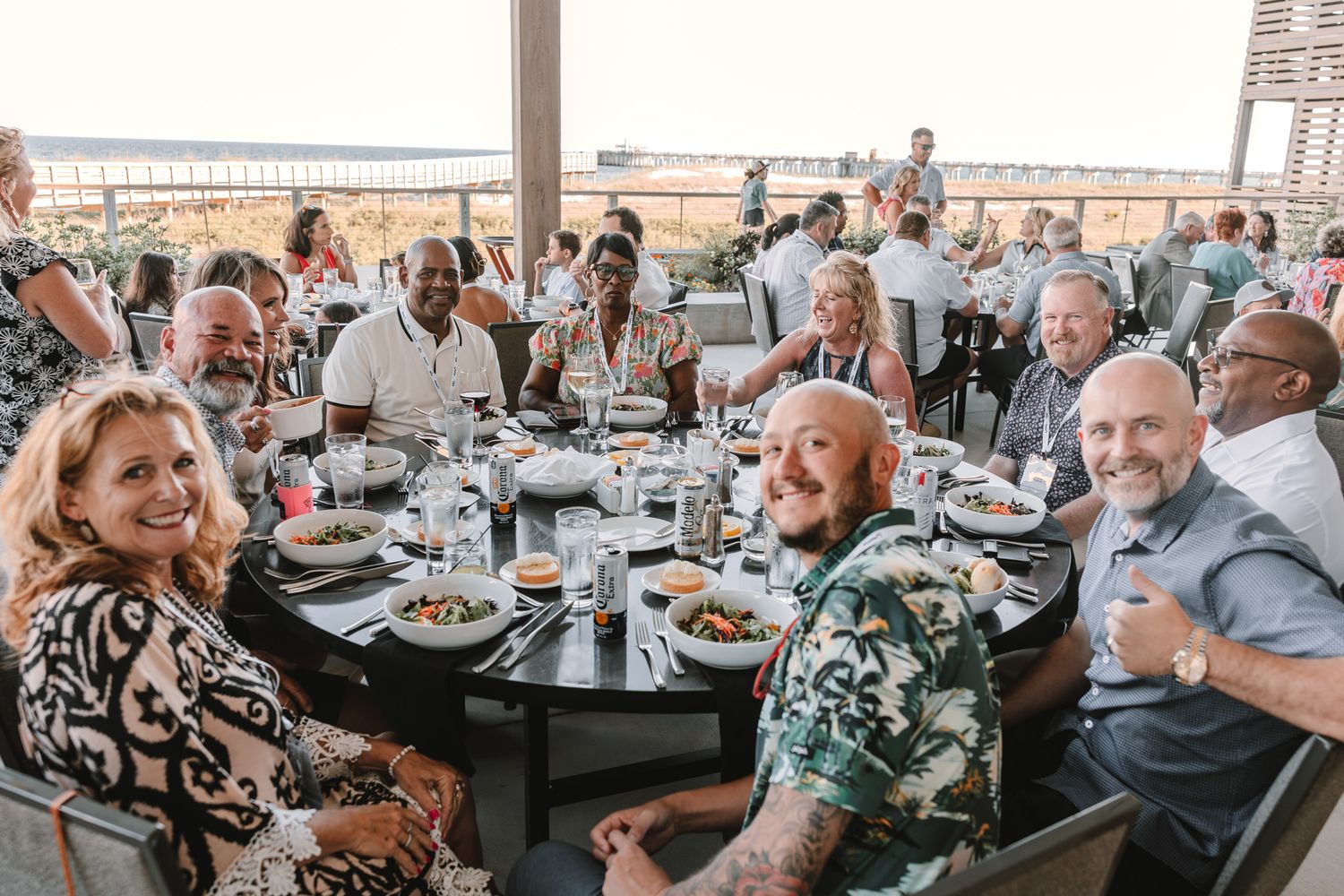 A group of people enjoying a meal together at a restaurant with tables arranged in a row.