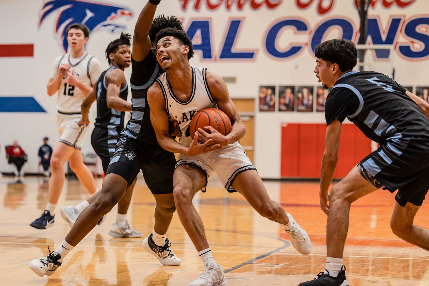 High school basketball players compete for the ball during an intense game on the court.
