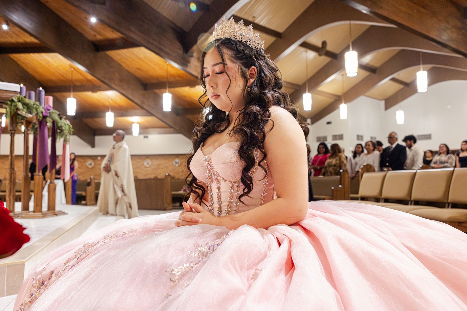 A bride in a pink ballgown twirls on a dance floor during a wedding celebration.