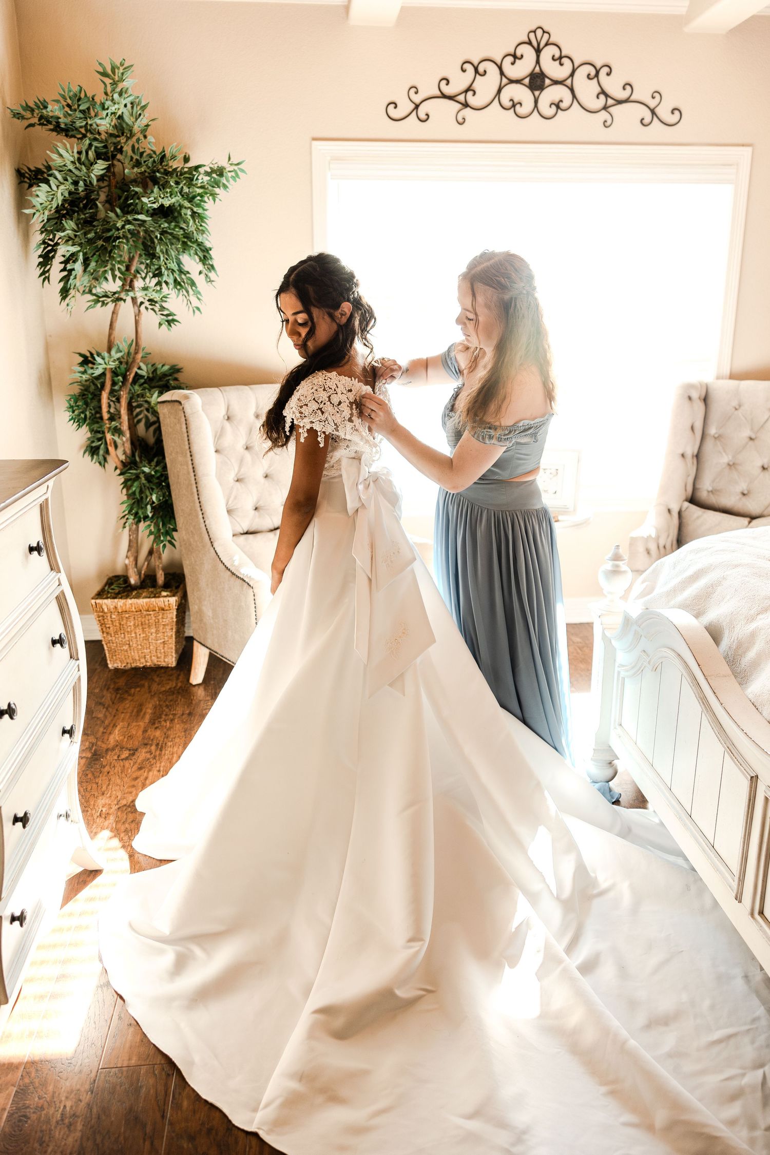 Sequence of bride getting ready in sunlit room with flowing white dress and bridesmaids in blue.