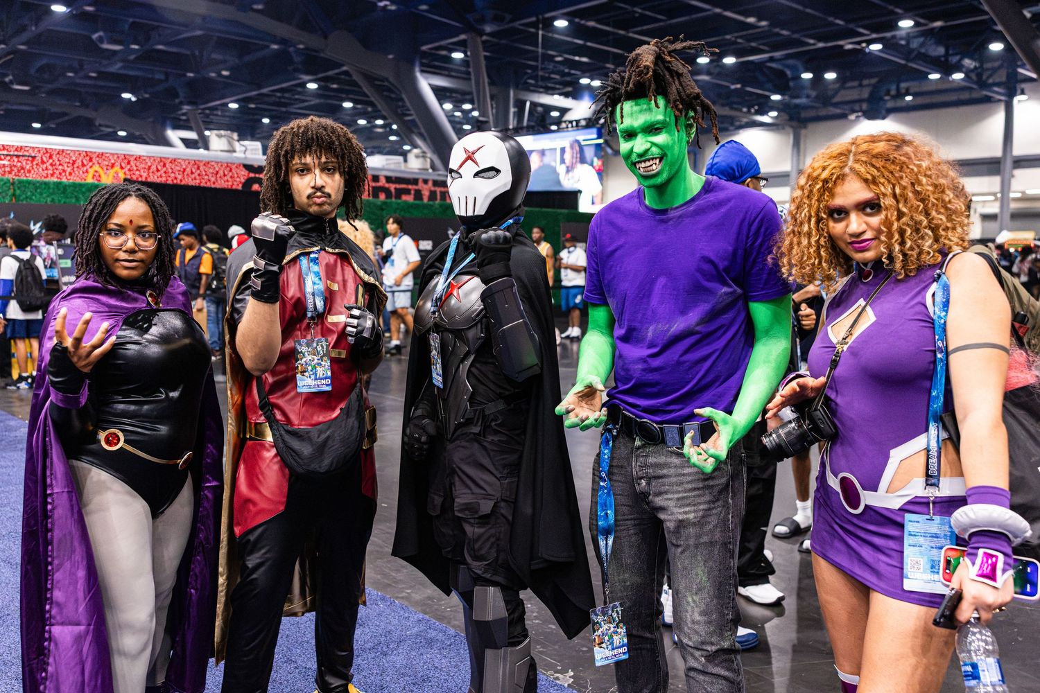 Group of five cosplayers dressed as Teen Titans characters at a comic convention.