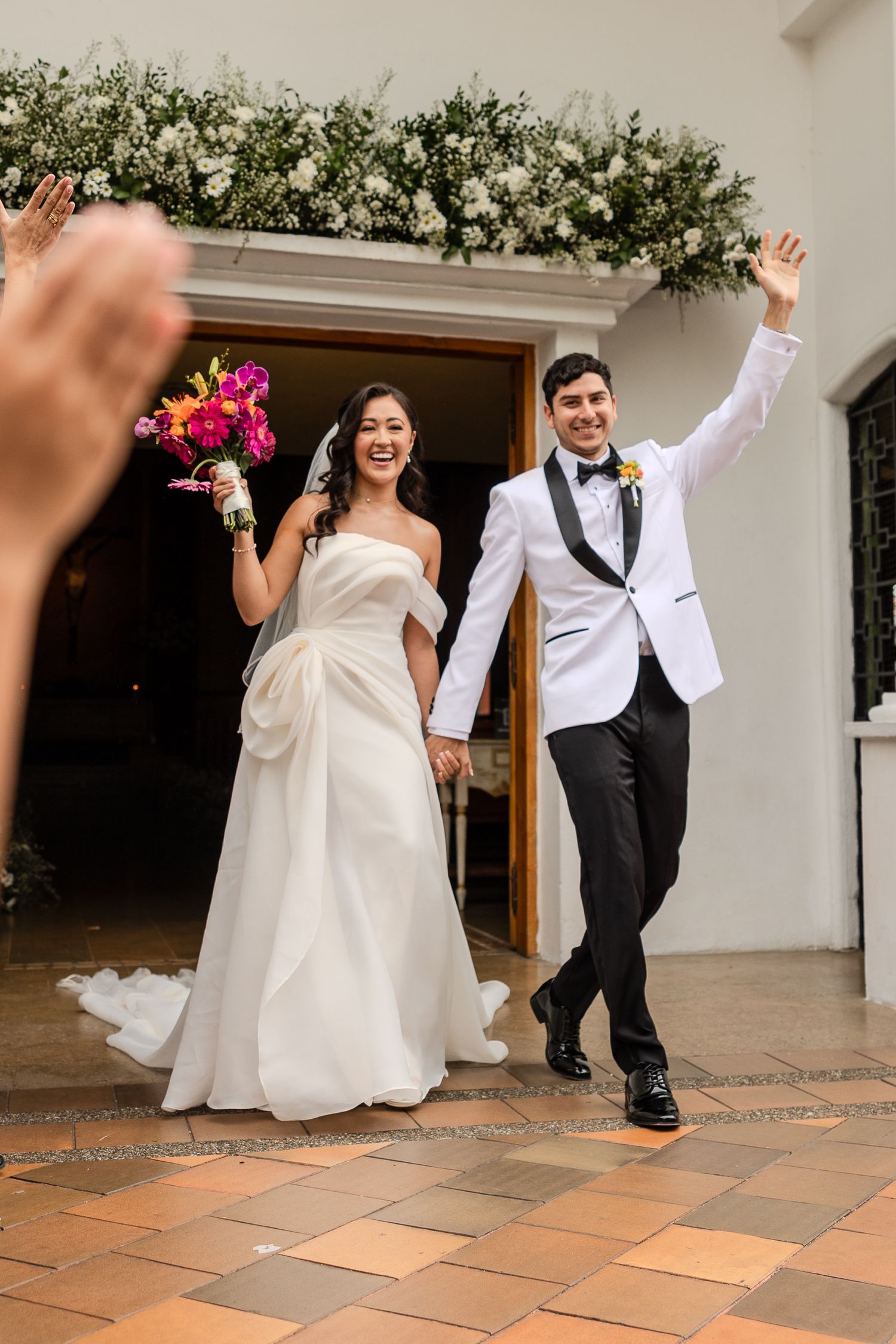 Wedding couple dancing and celebrating on outdoor terracotta tile patio.