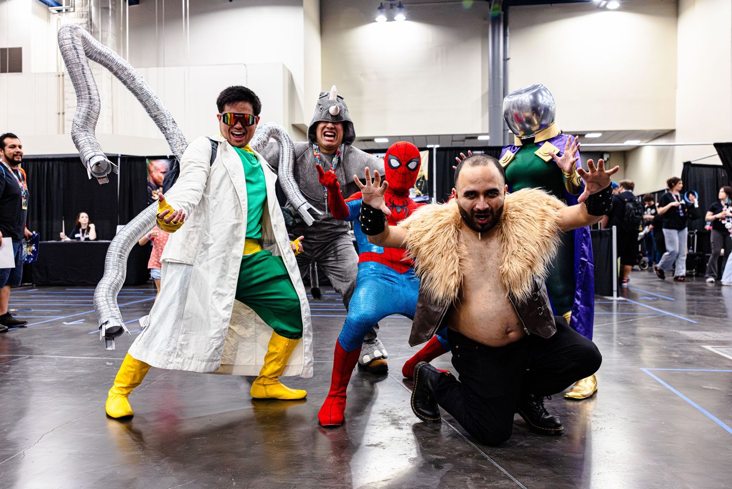 Group of cosplayers dressed as Marvel Spider-Man villains and heroes posing at a comic convention.