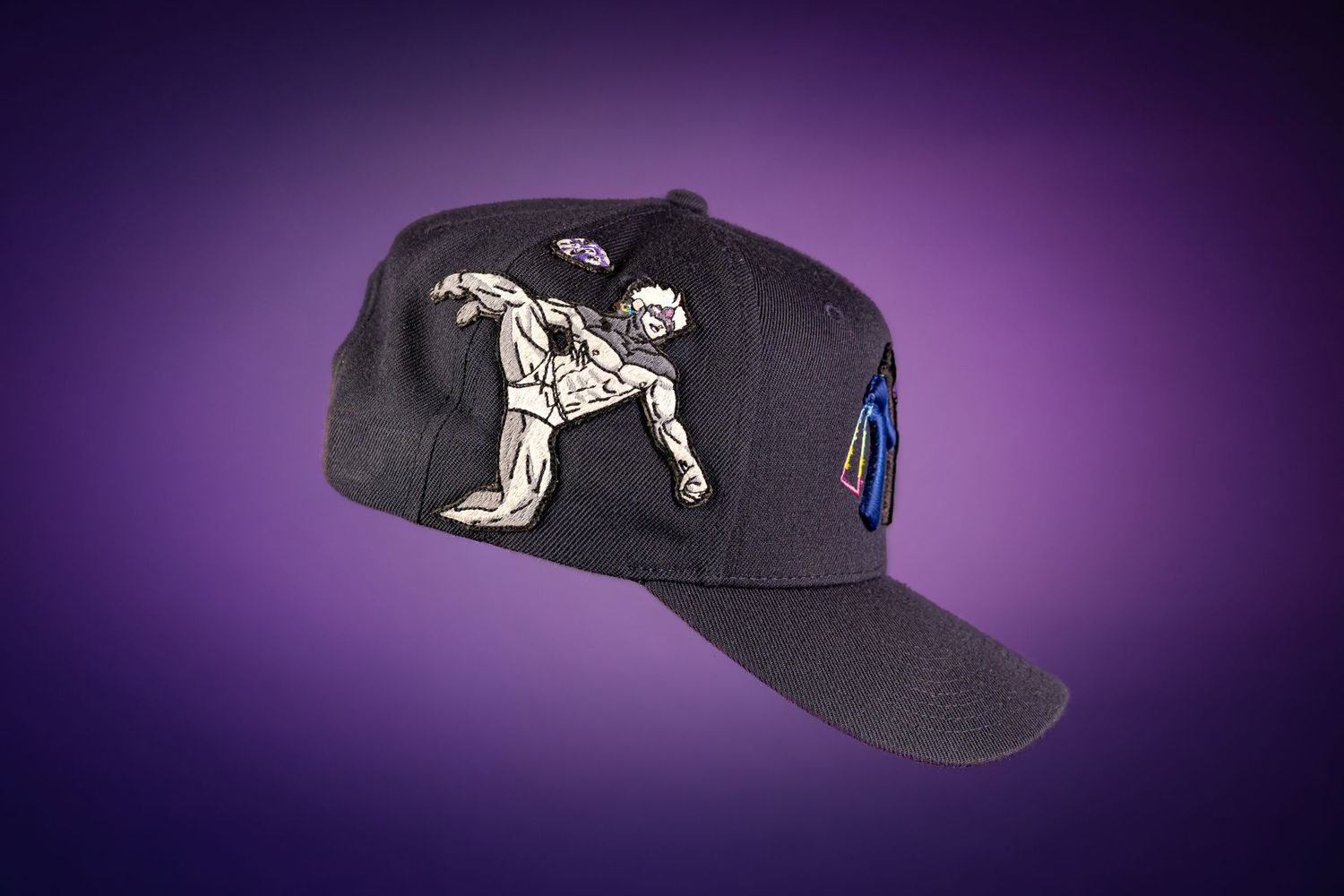 Black snapback cap featuring hand-drawn martial arts figure artwork on purple gradient background.