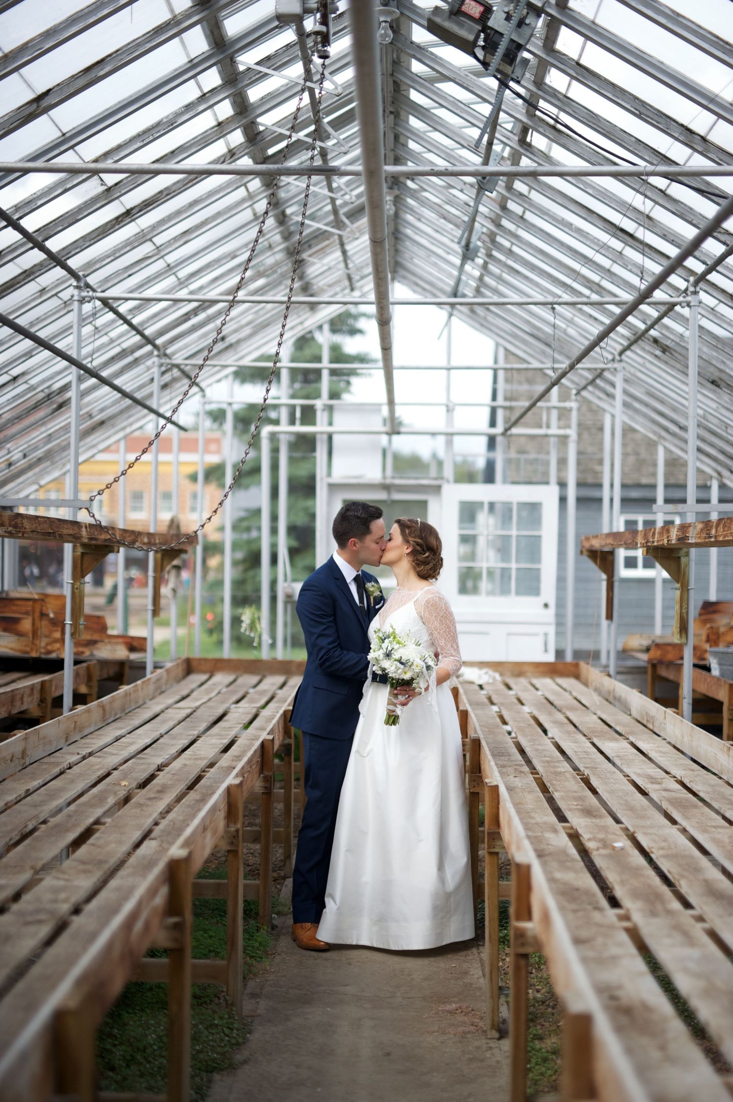 Greenhouse elopement kiss between bride and groom. Intimate Alberta wedding in a unique indoor venue.