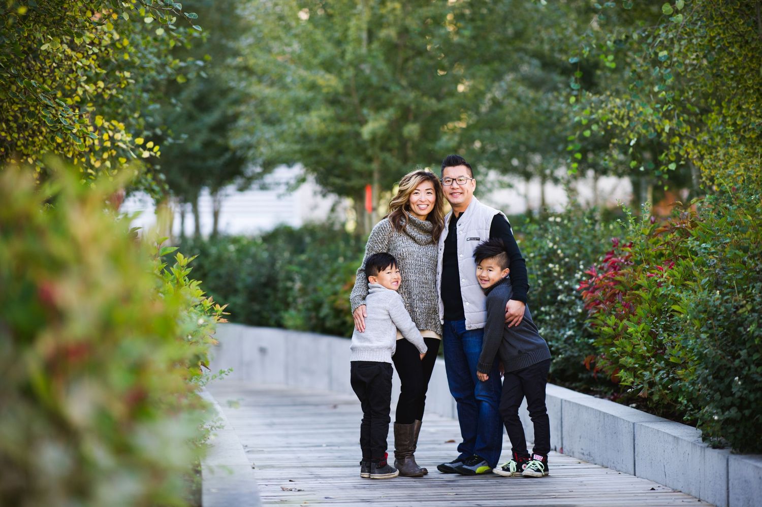 Family walking along a landscaped path, arms around each other, surrounded by lush greenery.