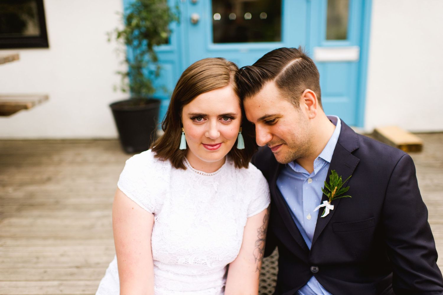 Close-up bride and groom at backyard elopement. Modern wedding couple by blue door, relaxed and romantic.