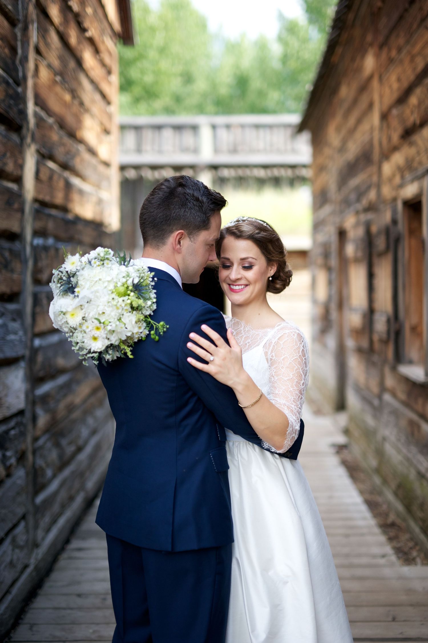 Newlyweds embrace gently, bride smiling with eyes closed while groom holds her tenderly.