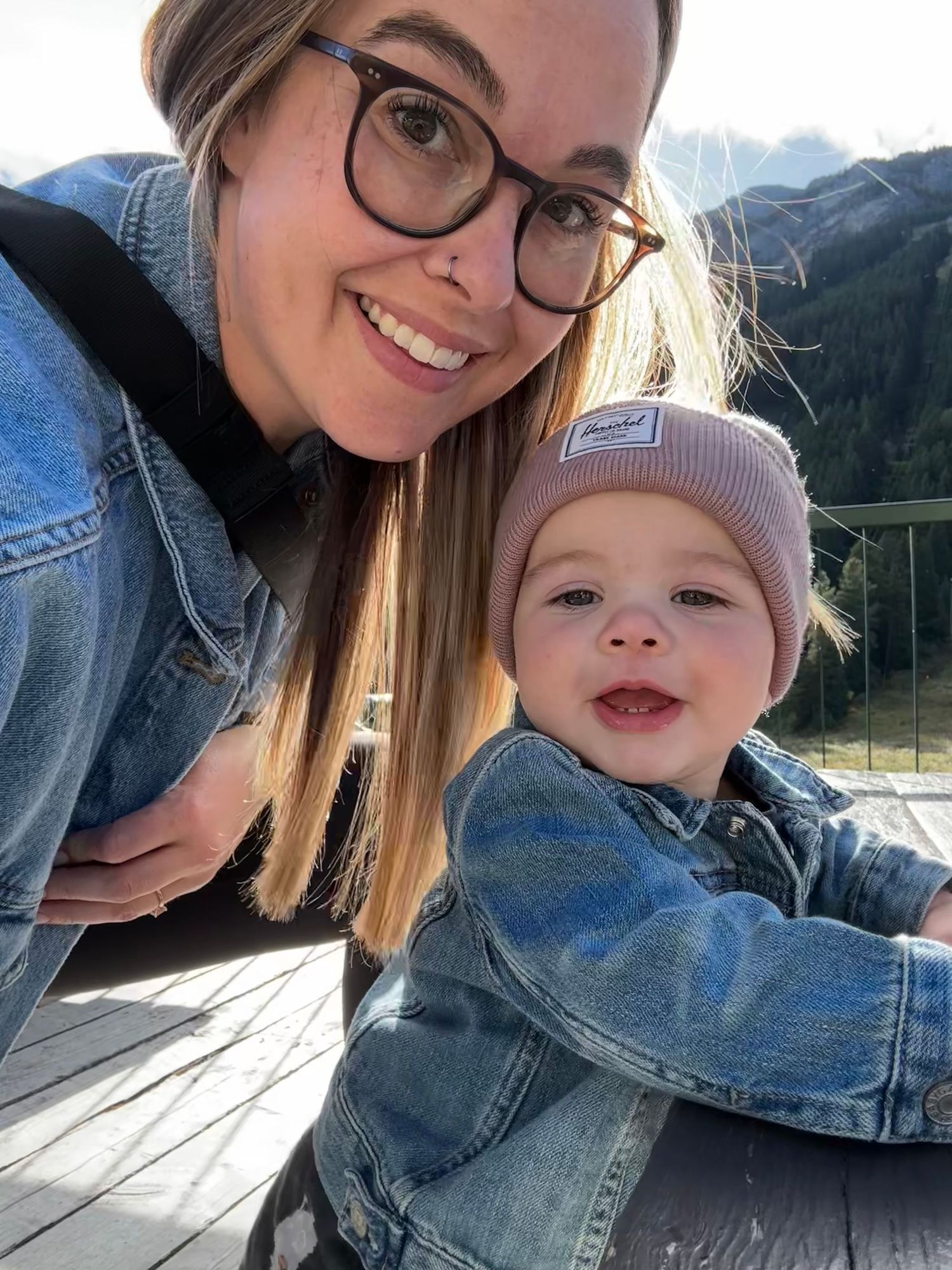 Mom and baby selfie in matching denim. Bright, candid family photo with mountain light and real smiles.