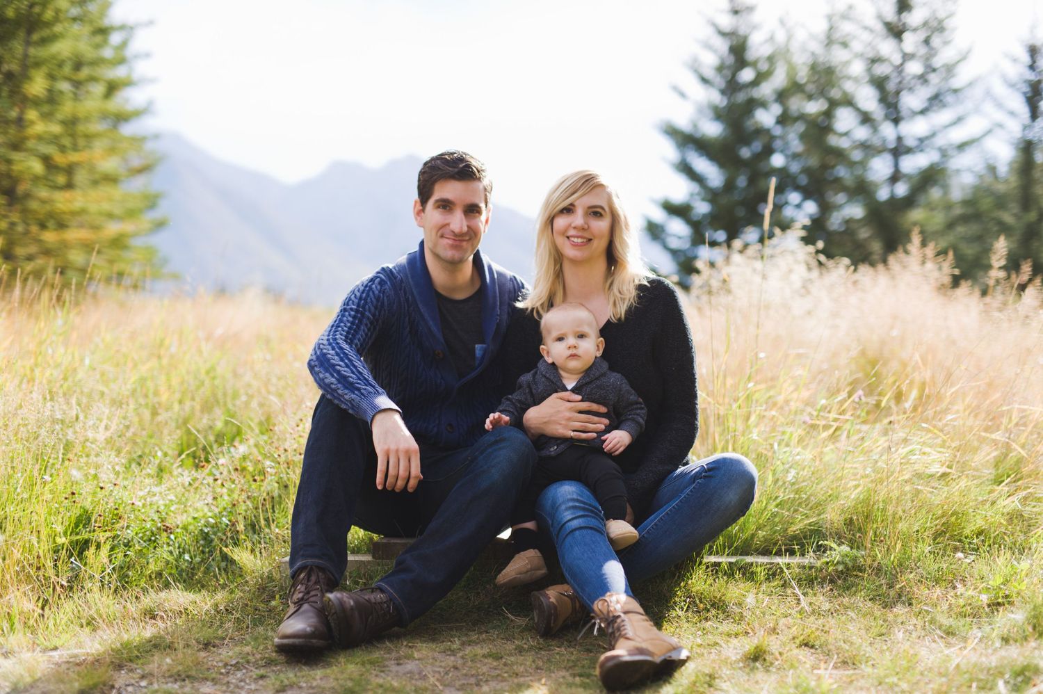 Mountain meadow family photo with toddler in lap. Natural Alberta outdoor session with love and calm.