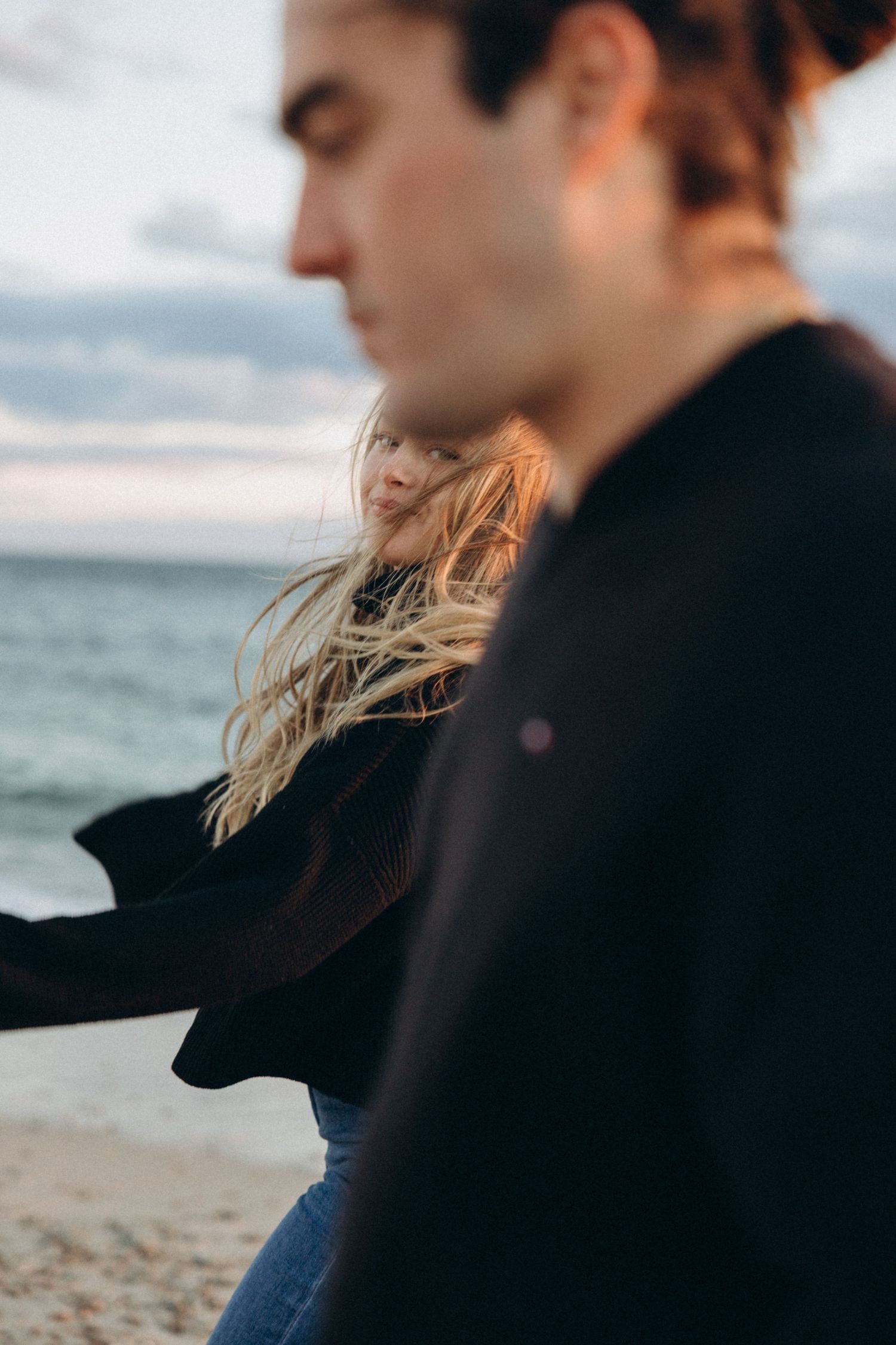 Artistic beach portraits focusing on silhouettes and profiles against an ocean backdrop.