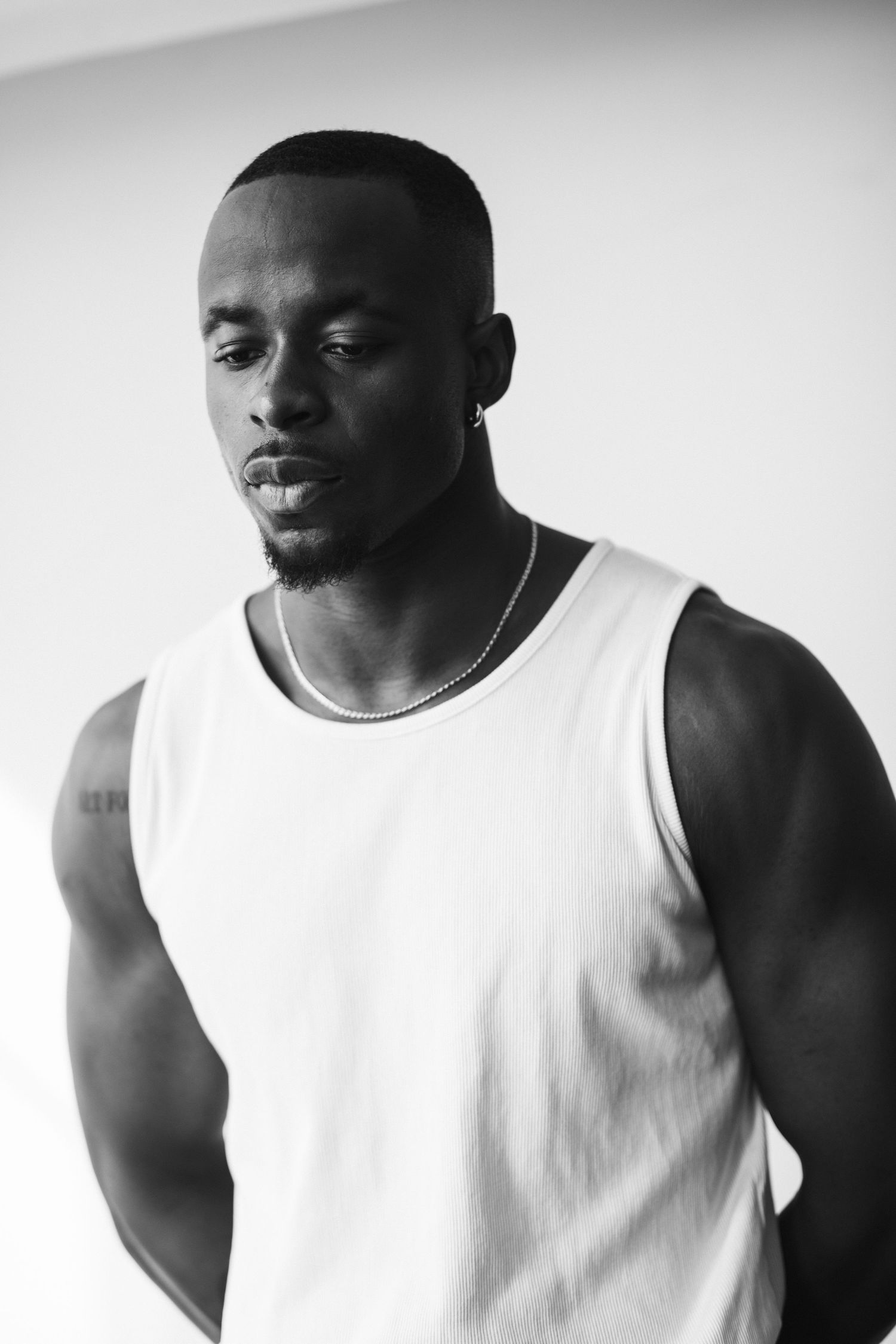Minimalist black and white portrait series featuring a white tank top against a light background.