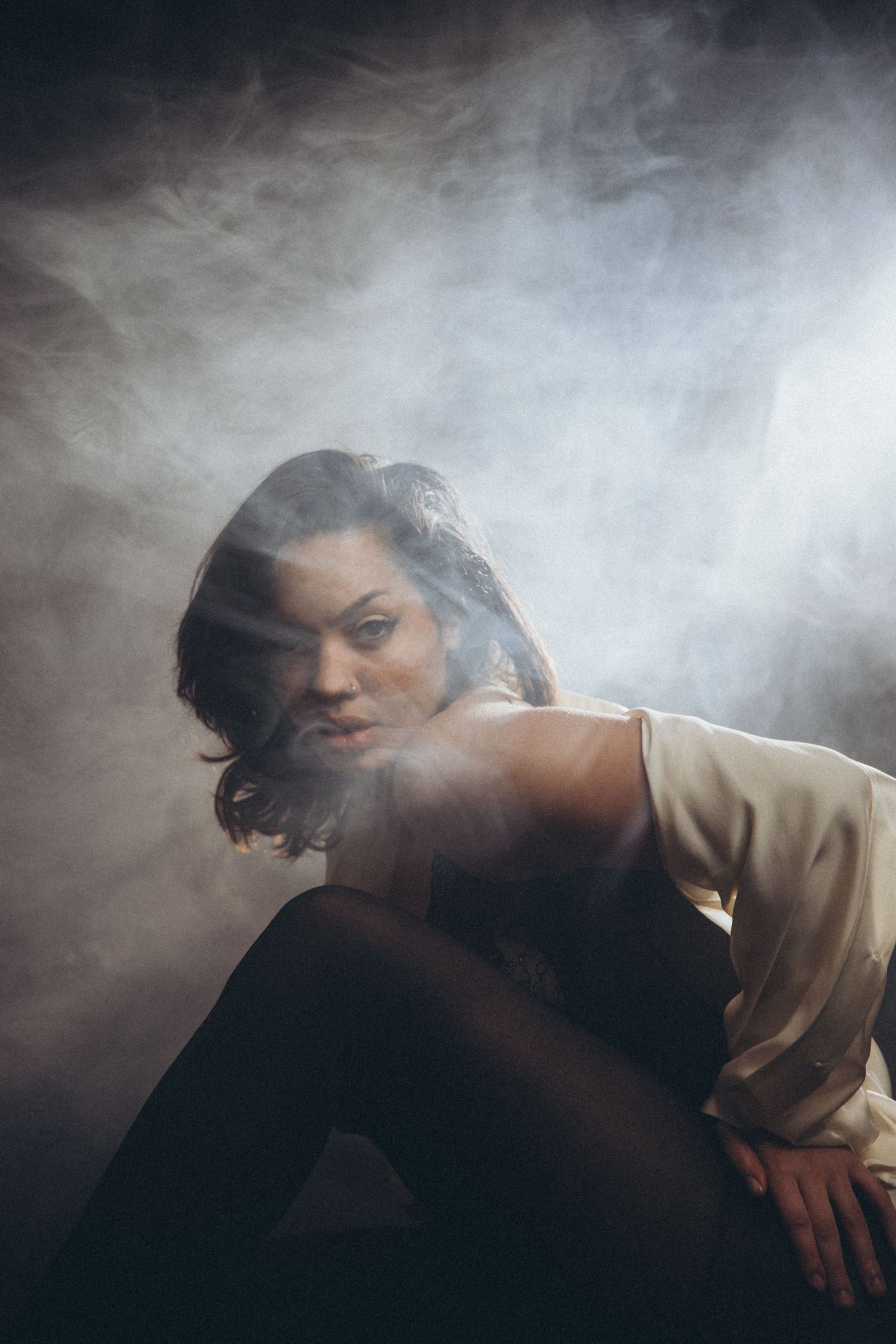 Atmospheric portrait with smoke effects and dramatic side lighting.