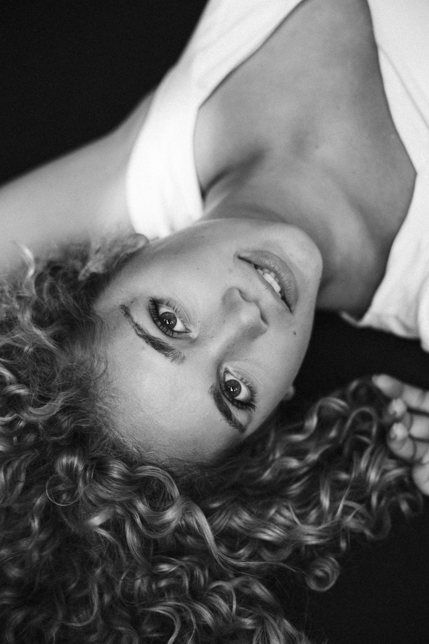 Intimate black and white close-up portraits with curly hair and expressive angles.