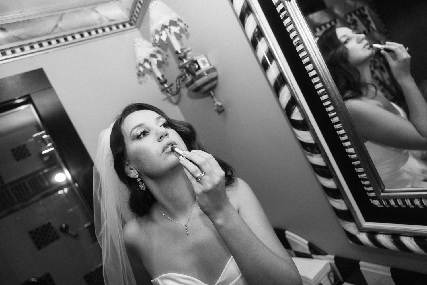 Wedding preparation moments captured in black and white through a vintage-style mirror.