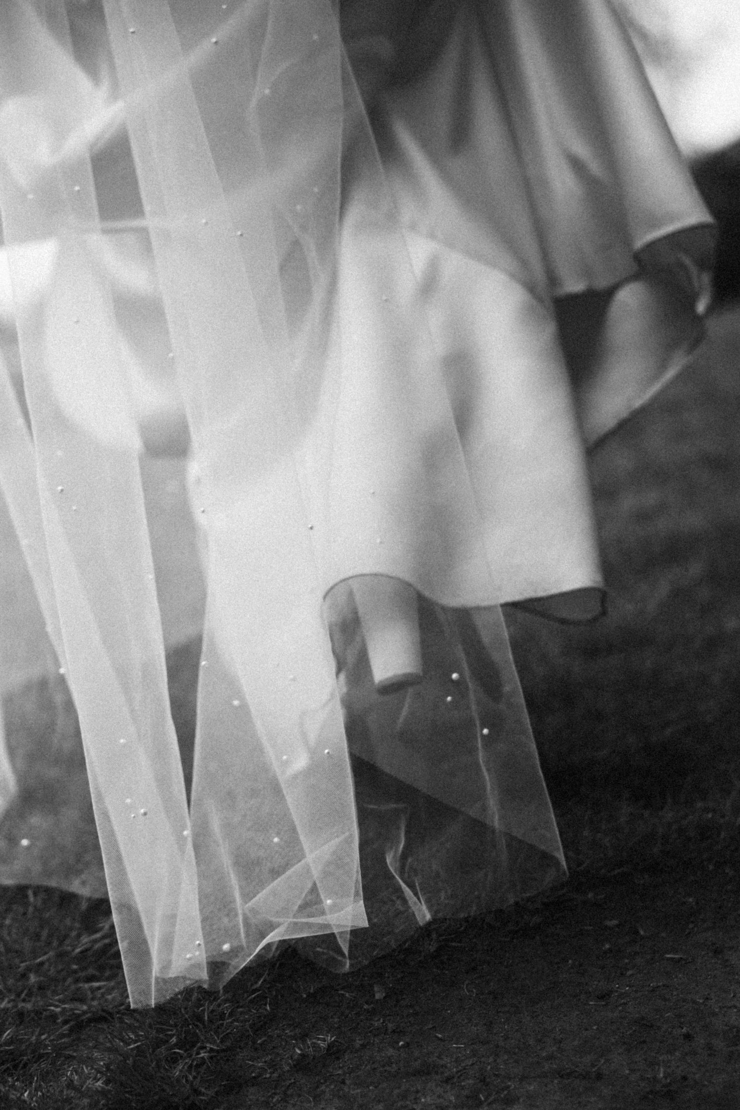 Close-up detail shot of white tulle wedding dress fabric and veil.