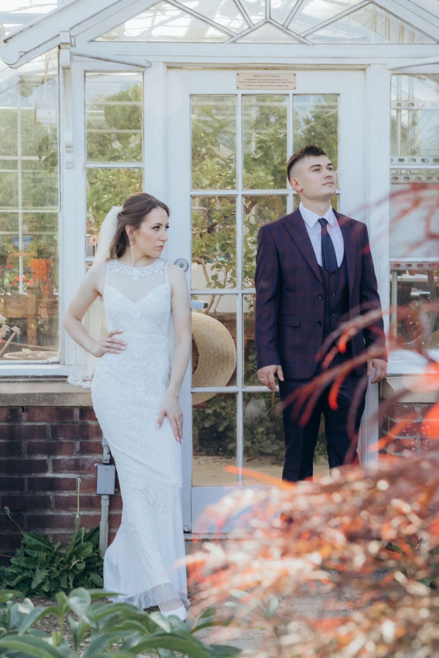 Wedding photography in a glass conservatory with autumn foliage.