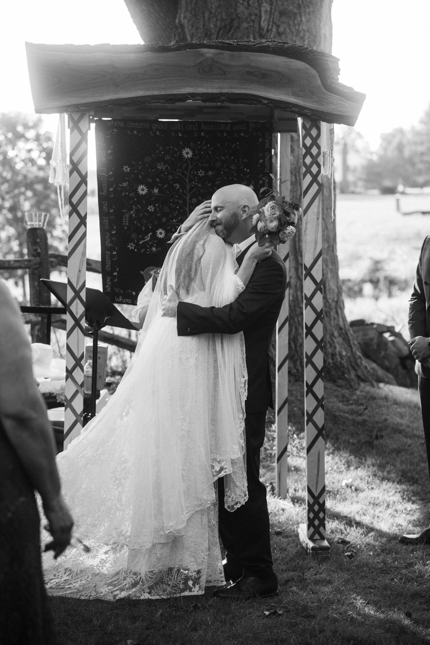 Black and white sequence of wedding couple dancing under pavilion.
