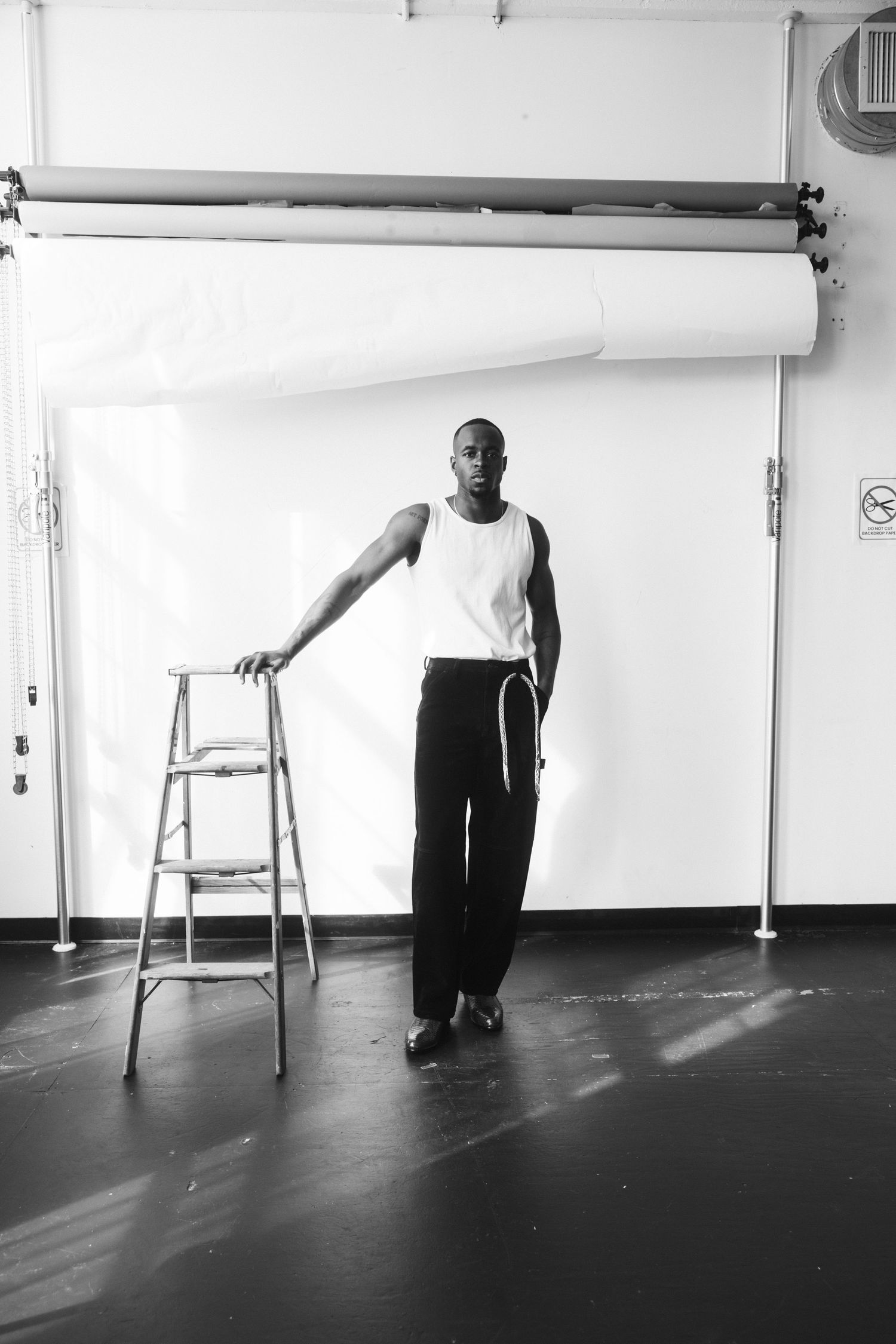 Modern dance performance captured in black and white with a ladder prop.
