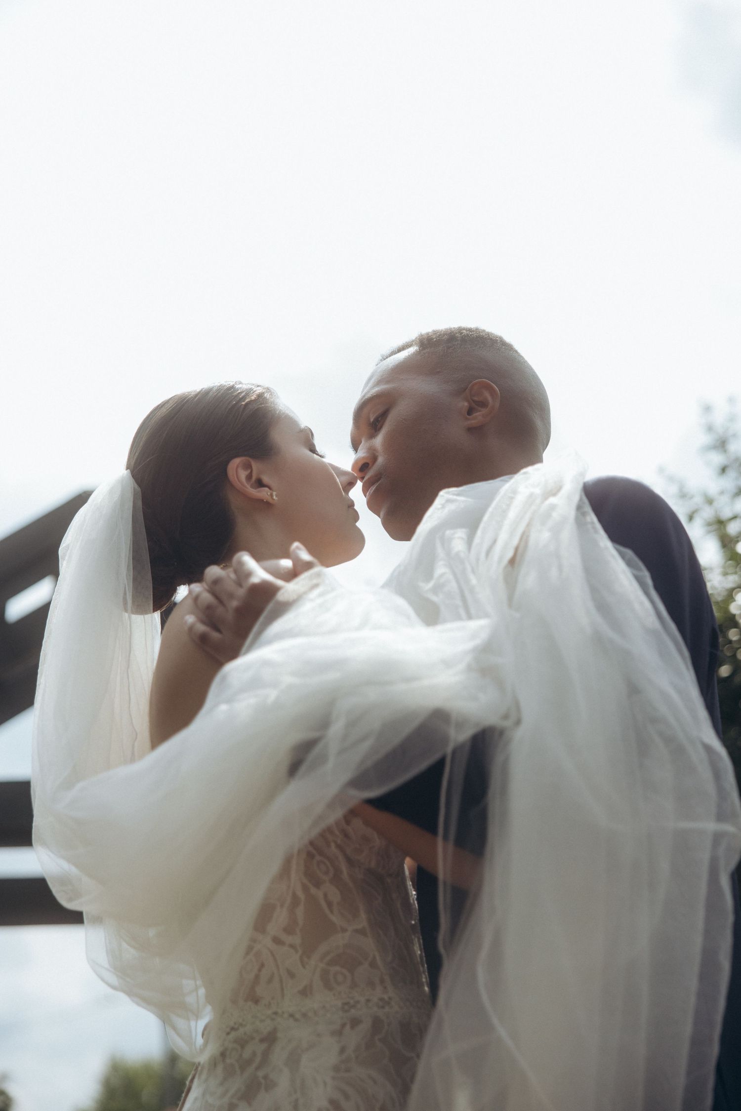 Artistic wedding portrait sequence against a bright sky background.