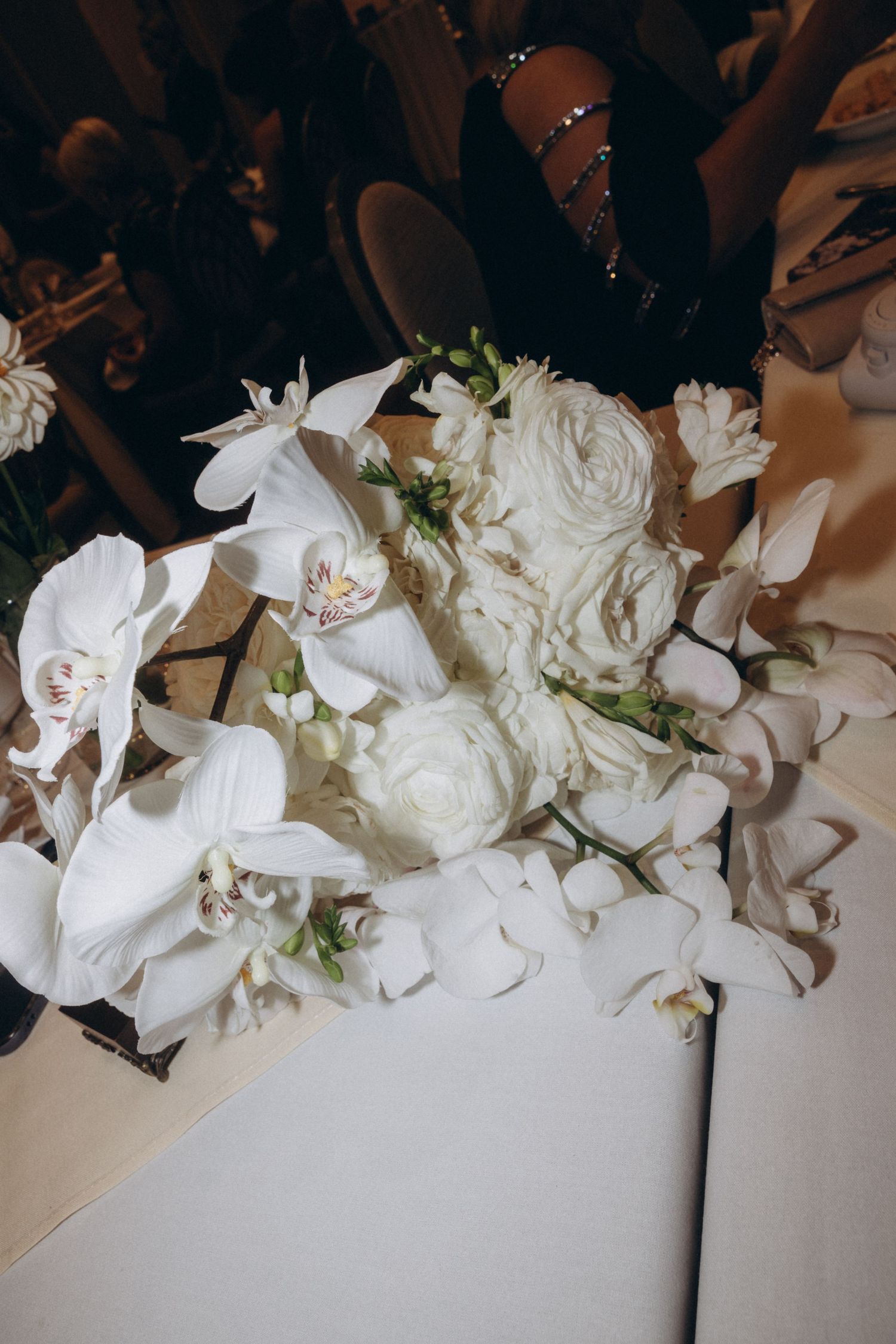 Elegant white floral arrangements with roses and orchids create a romantic wedding backdrop.
