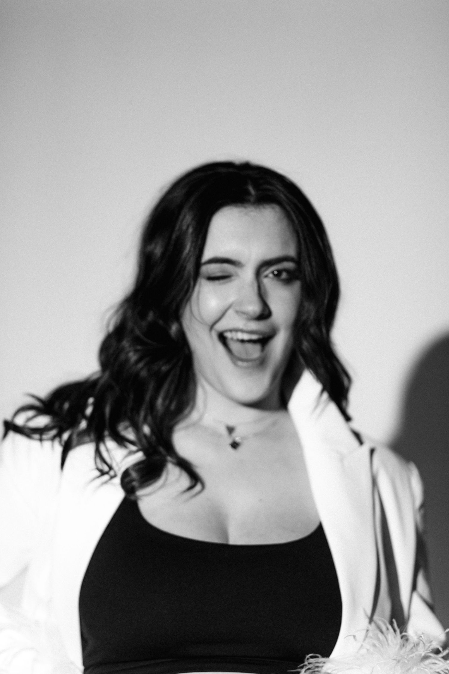 Expressive black and white portrait showing joyful moment against light background.