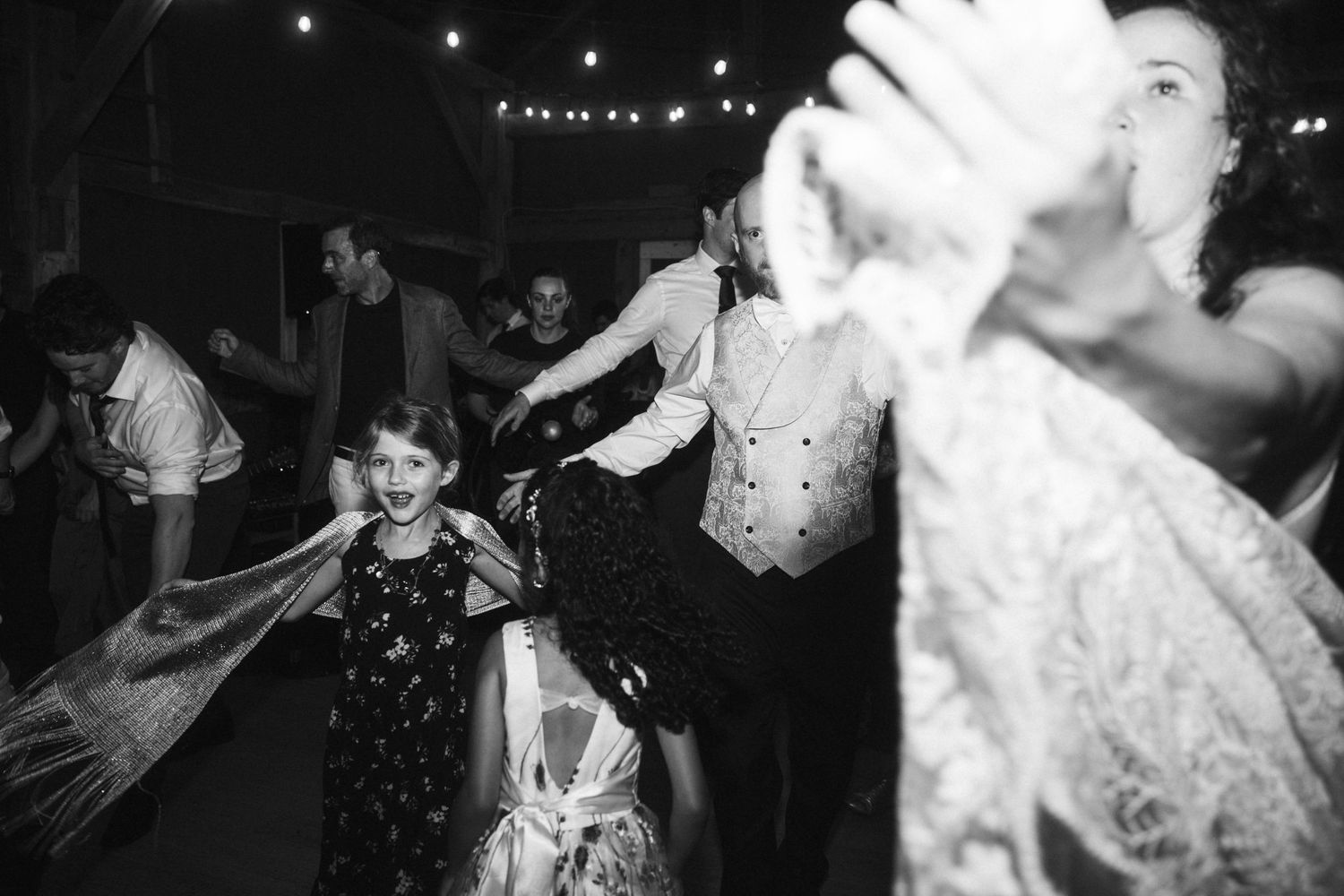 Wedding couple performs a choreographed dance routine surrounded by guests at an evening reception.
