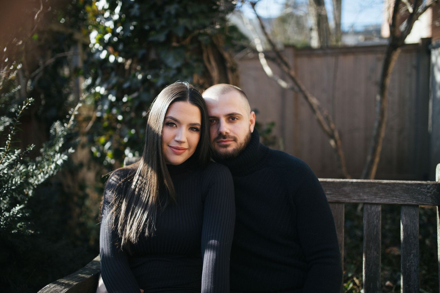 Romantic couple photos in a backyard garden with string lights and greenery.