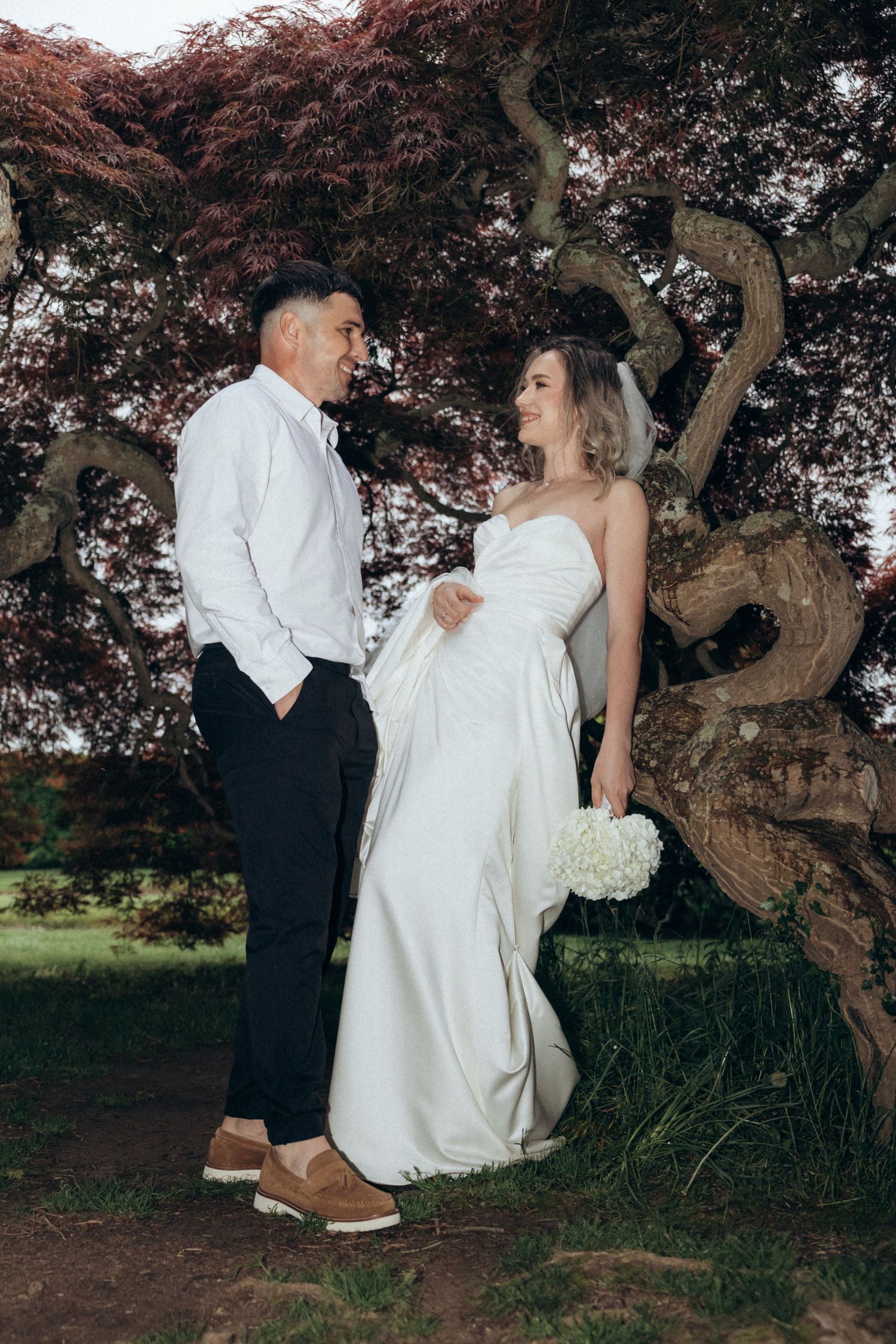 Wedding couple sharing intimate moments under a Japanese maple tree.