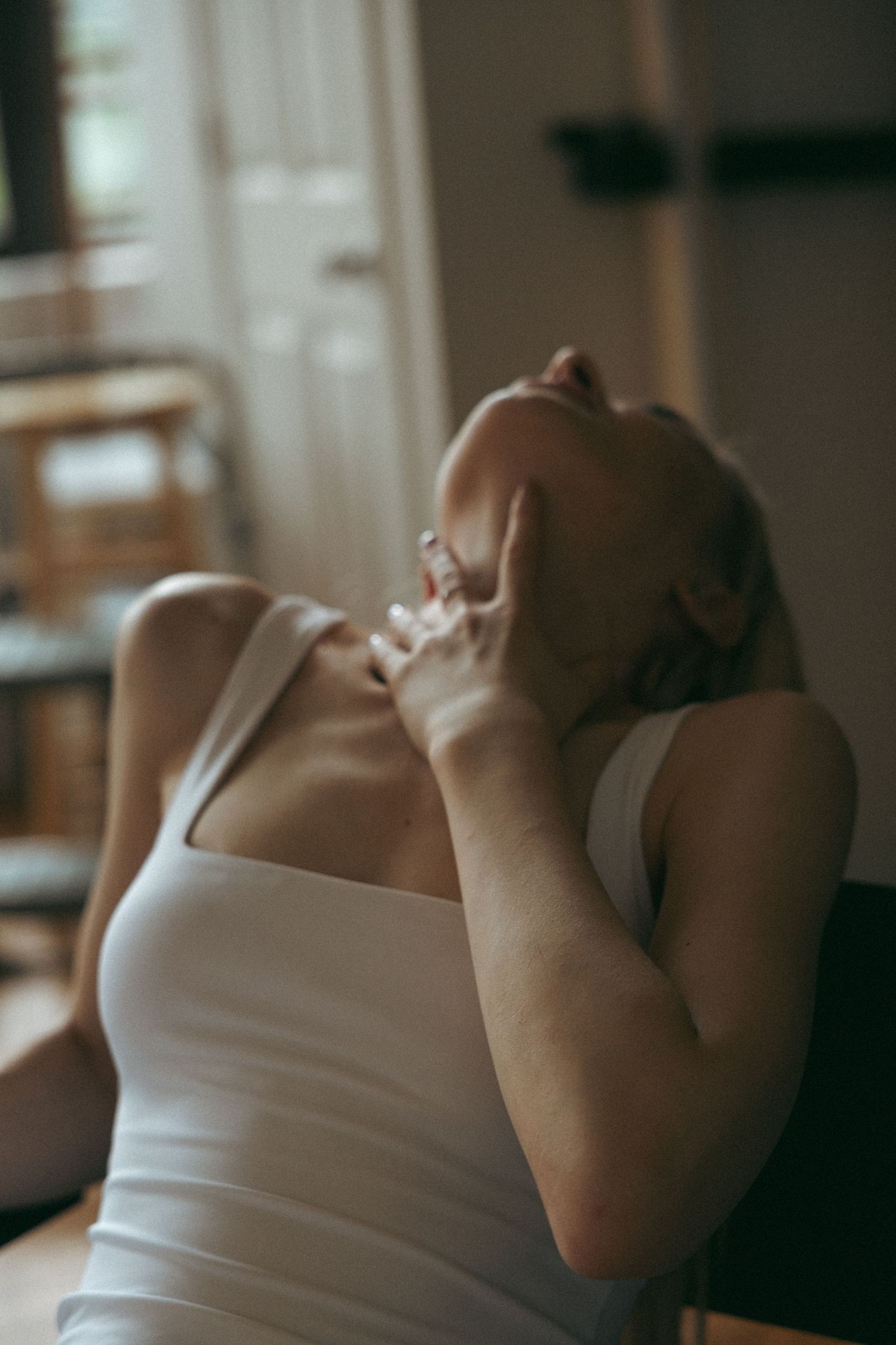 Intimate portrait series in soft lighting featuring white tank top.