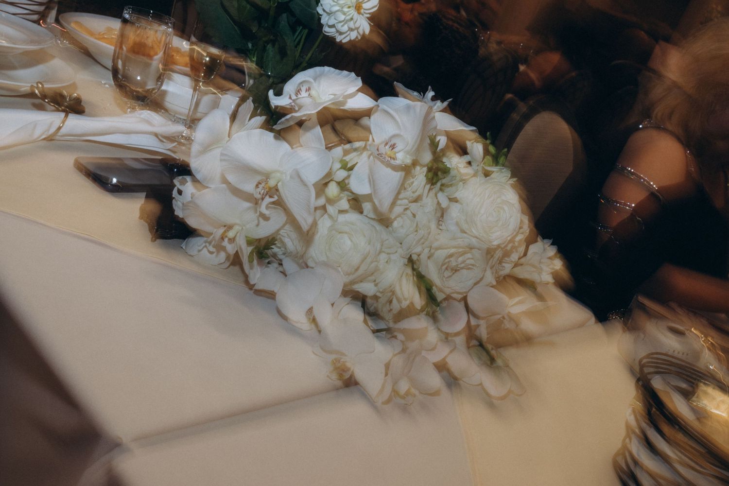 White floral table decorations lined up for an elegant wedding reception.