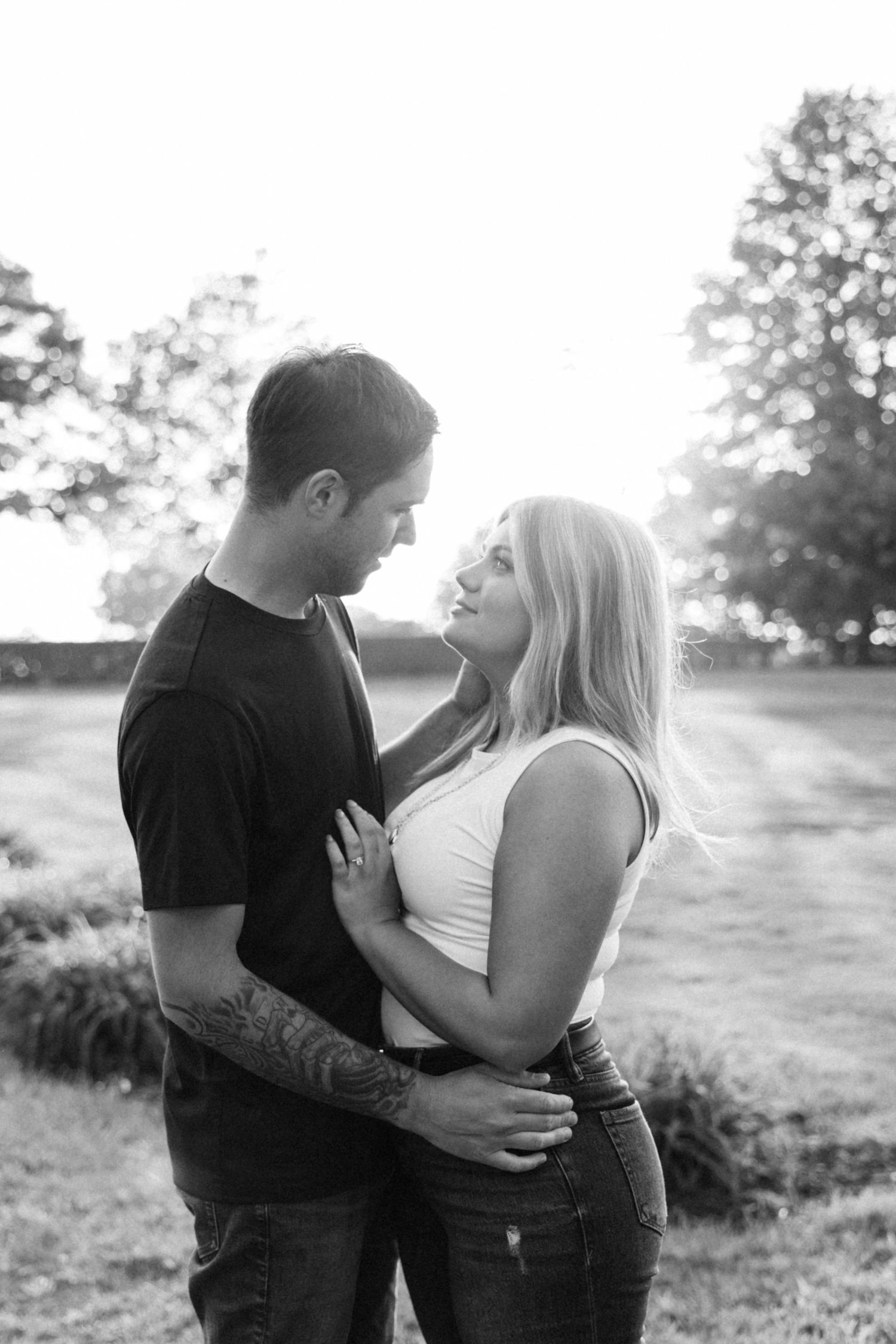 A couple sharing an intimate moment outdoors during sunset in a natural setting.