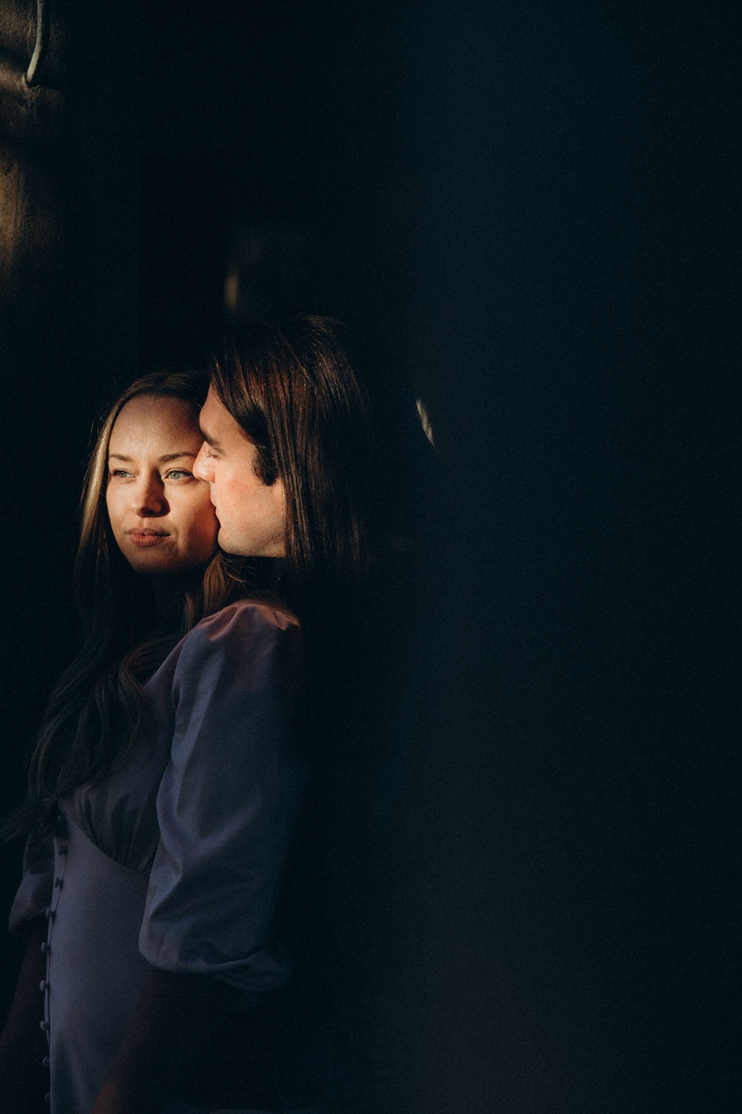 An artistic dark portrait with dramatic shadows and intimate poses.