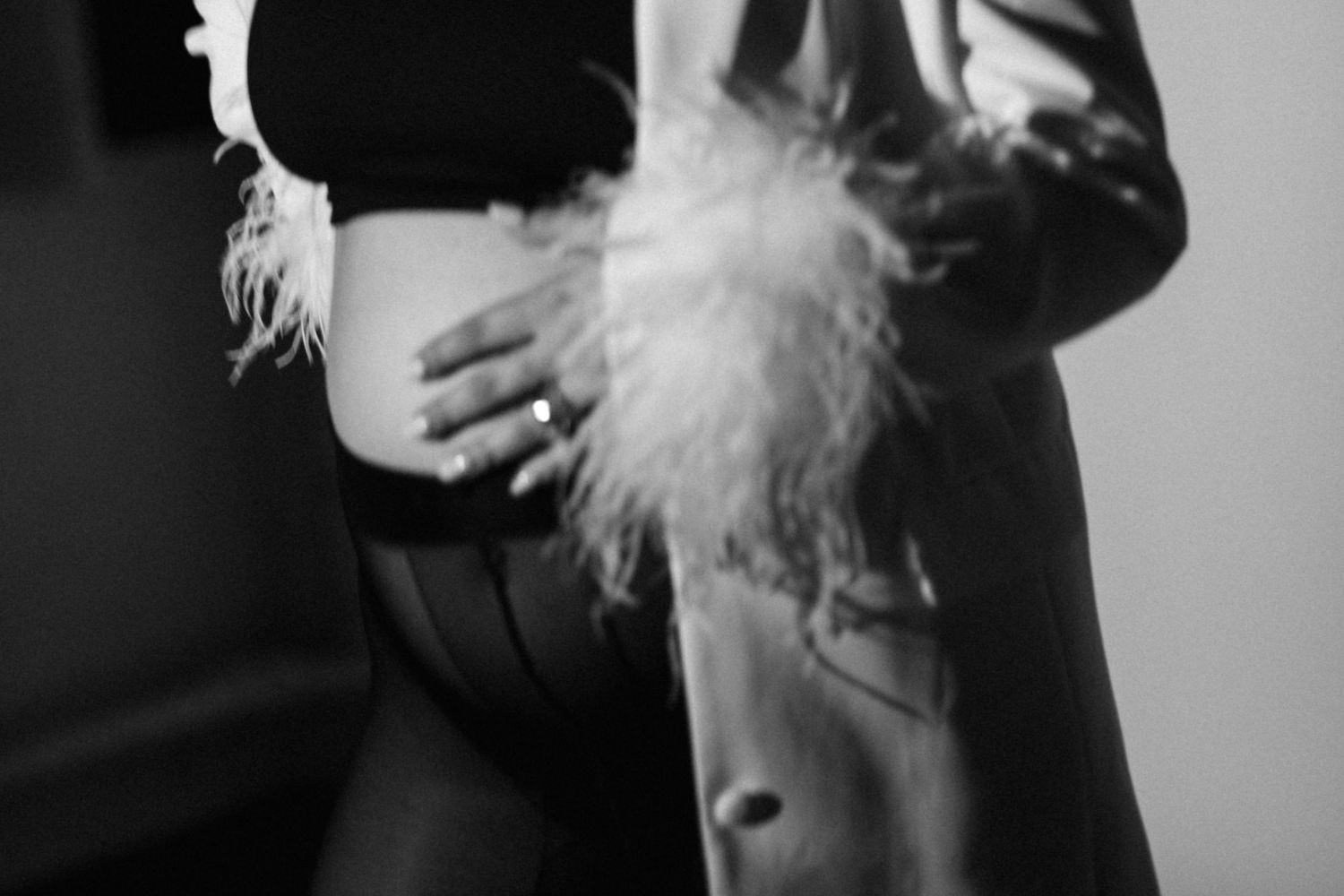 Close-up detail shot of feather trim and black fabric in monochrome.
