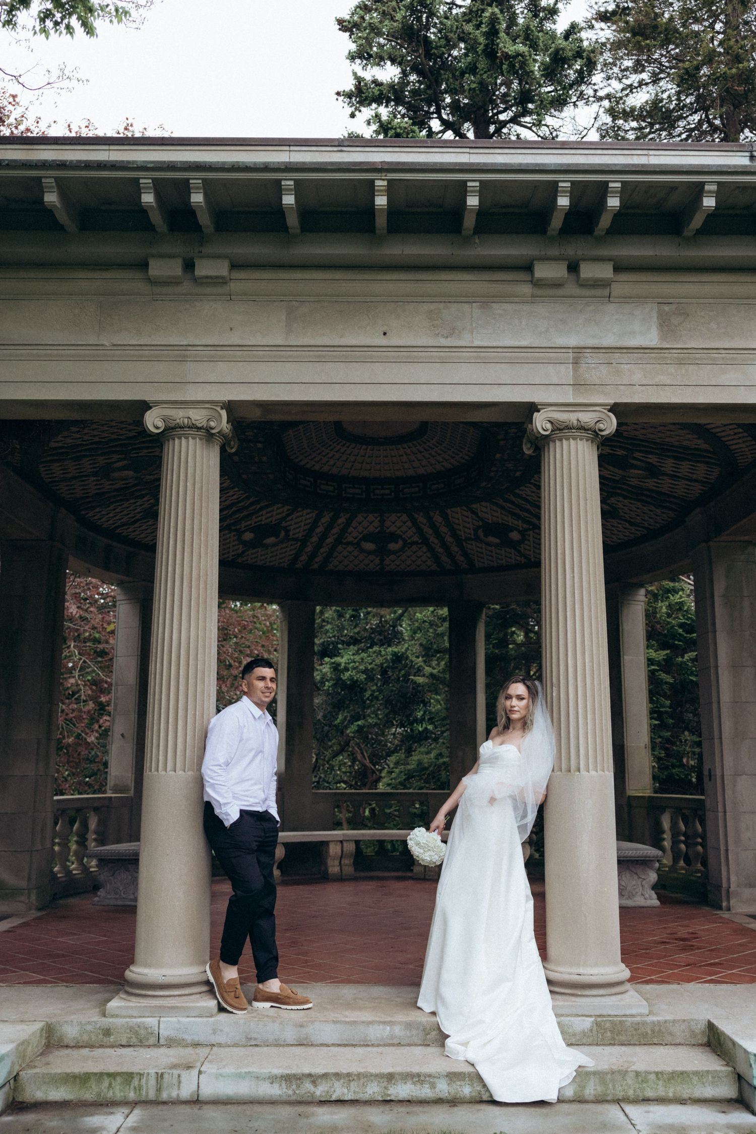 A series of romantic wedding portraits taken under a classical columned pavilion.