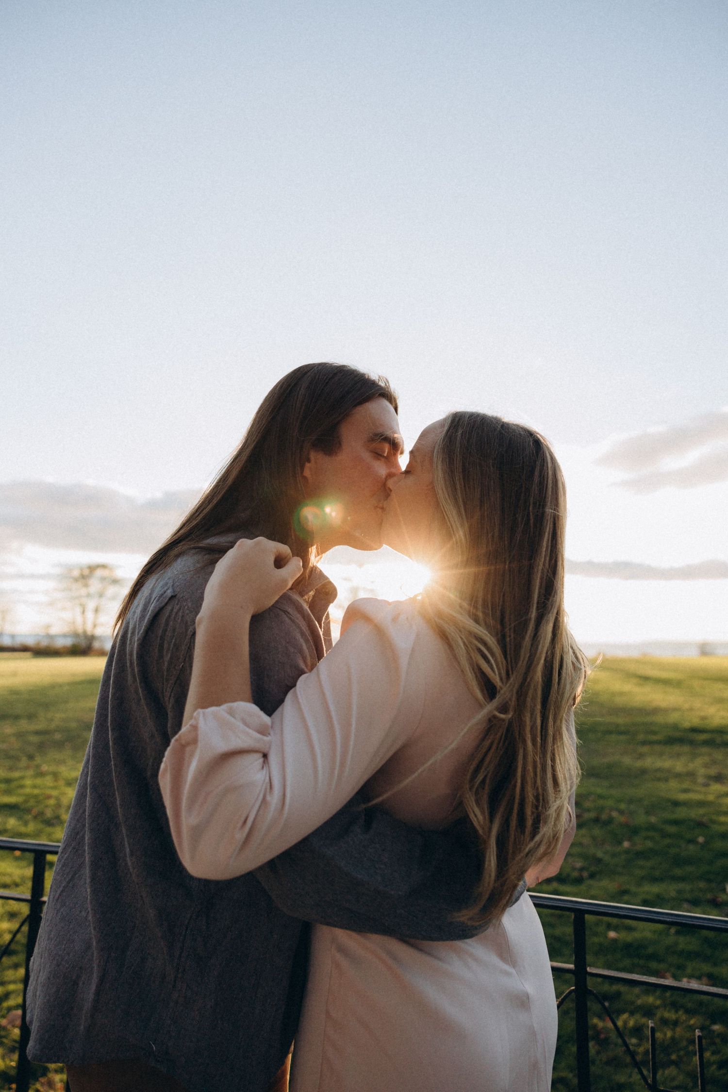 A silhouetted kiss at sunset with golden light streaming through the background.