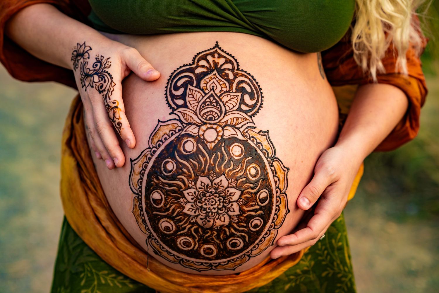 A series of photos showing a pregnant belly decorated with intricate henna designs in mandala patterns.