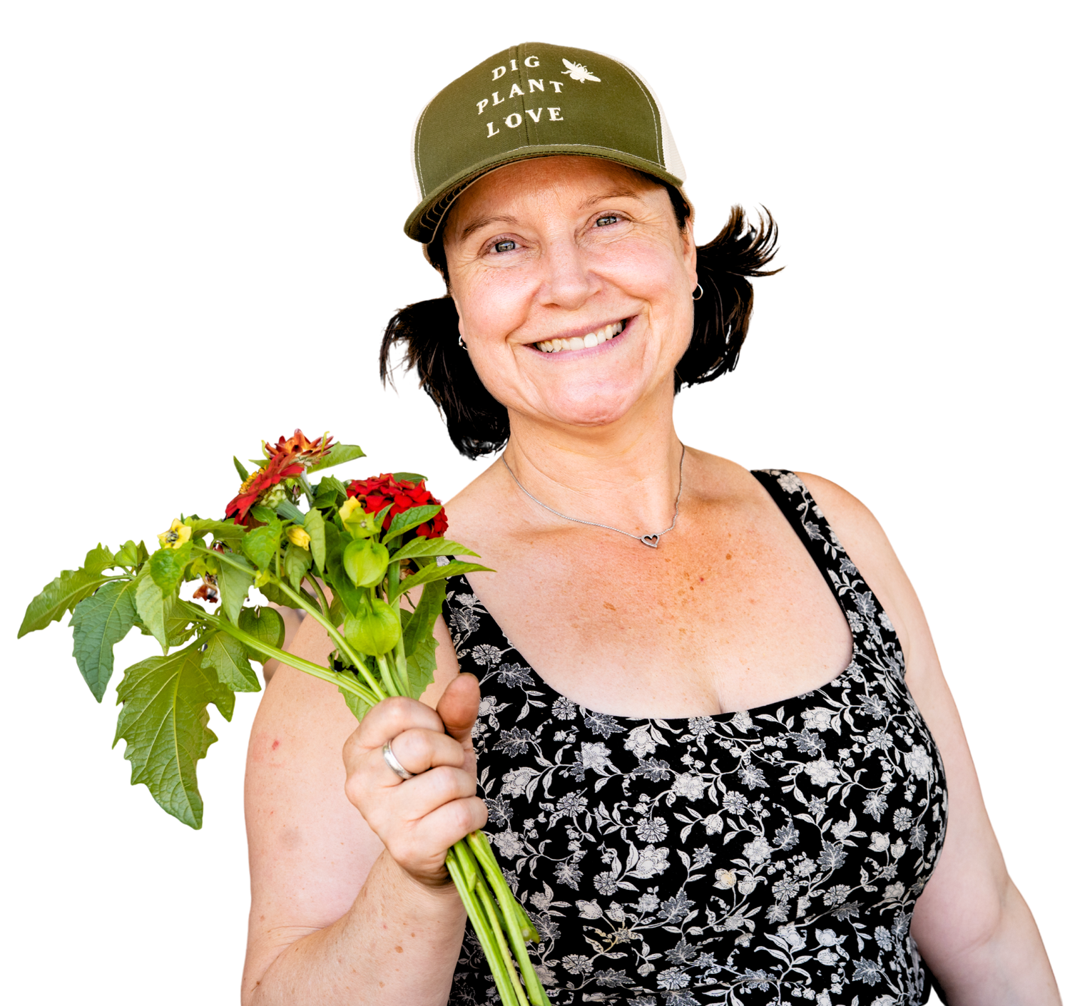 Smiling woman holding red flowers wearing a green cap and floral top against a white background.