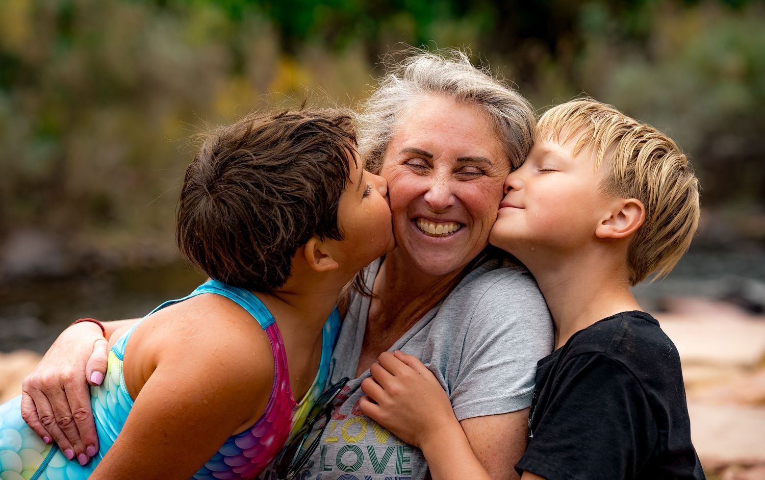 A collage of tender family moments shows parents and children sharing affectionate embraces outdoors.