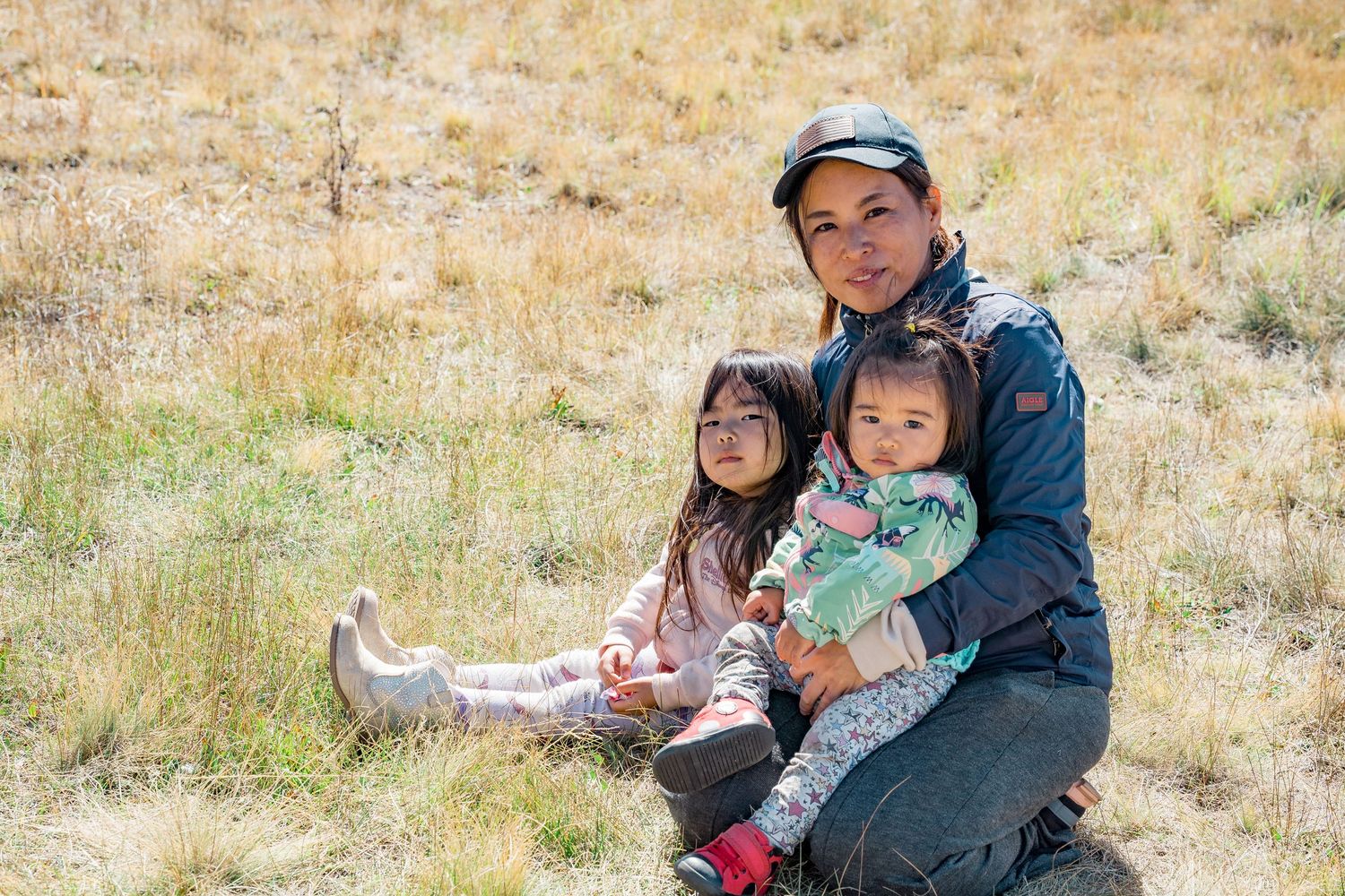 Family enjoying a fun outdoor adventure together in a grassy field on a sunny day.