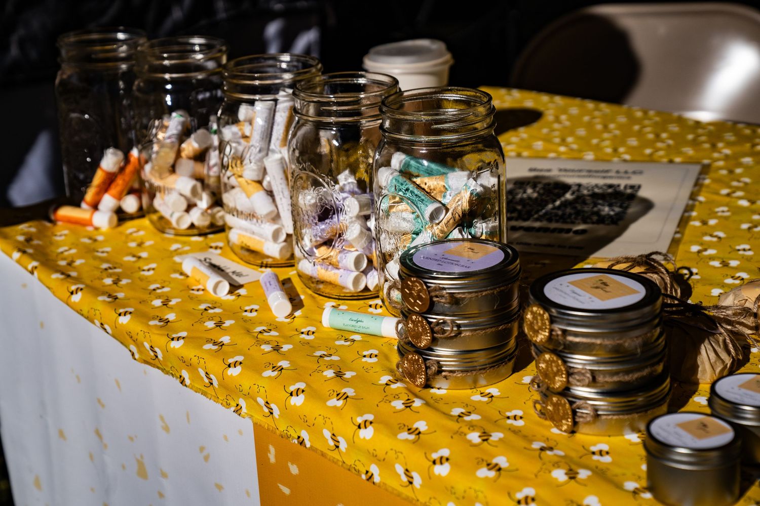 Jars of handmade chapstick displayed at the Bee Yourself Honey booth at the farmers market.