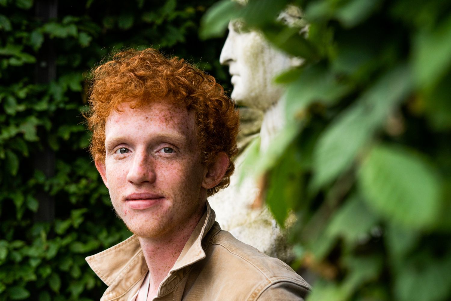 A series of portraits showing someone with curly red hair against a green leafy background.