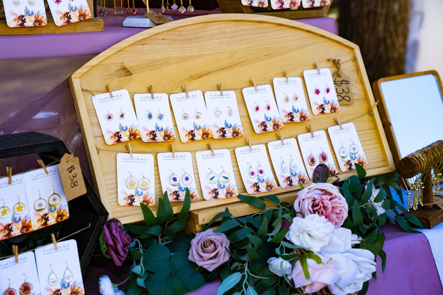 Close-up of earrings with hand-pressed flowers at the farmers market.