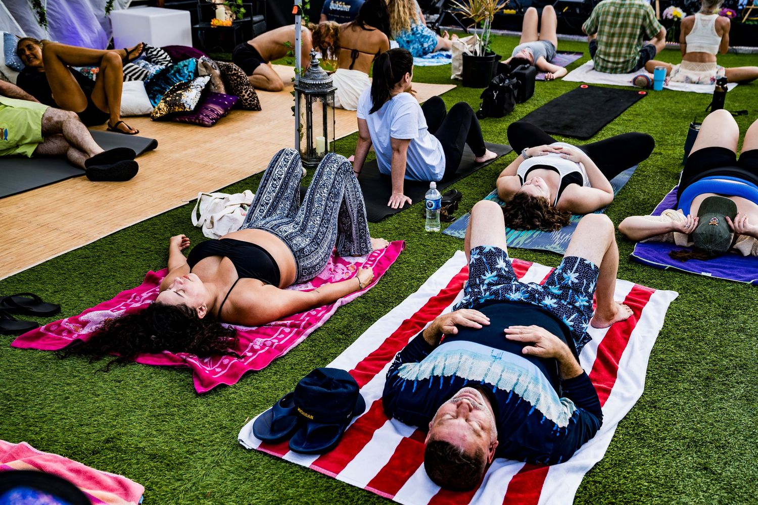 A photo of people lying down and relaxing on their yoga mats during a spiritual event.