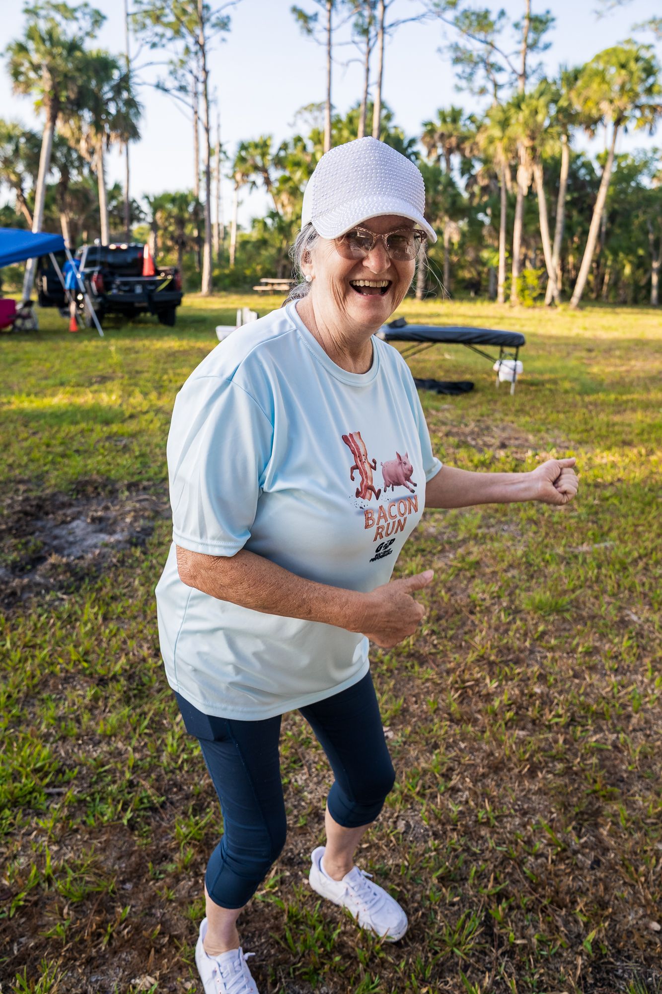A woman smiling excitedly at the camera as she prepares for a race.