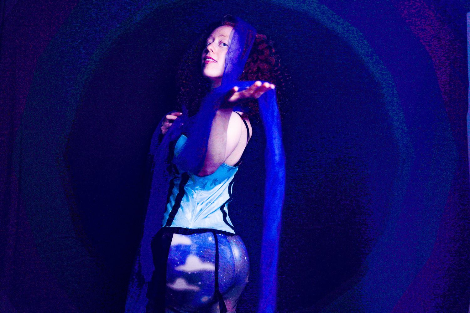 Concert performer silhouetted against dramatic blue stage lighting during a live music performance.