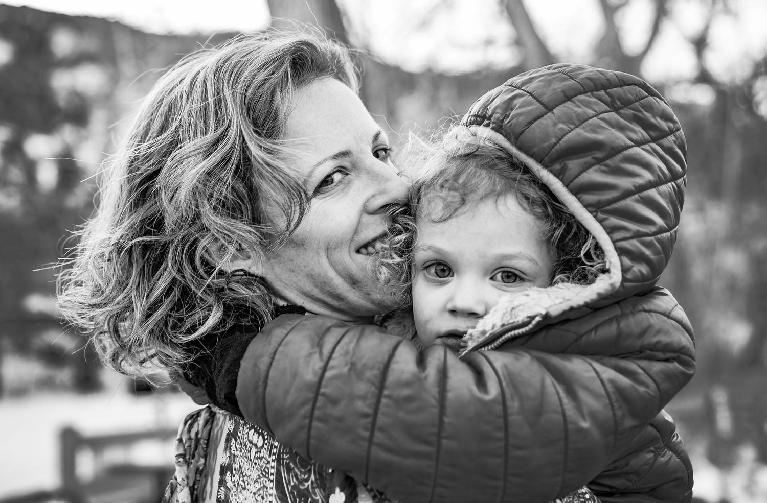 A black and white photo collage showing tender embraces and loving moments between parent and child outdoors.